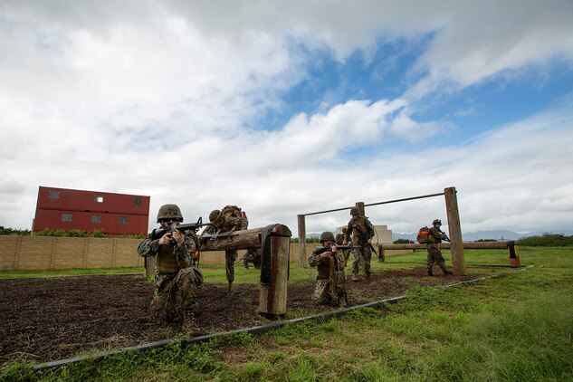 Marines provide security for their squad members as they advance positions on the obstacle course at Boondocker Training Area aboard Marine Corps Base Hawaii, Feb. 25, 2014. The Marines were participating in Corporals Course and completed a case study that took them through several training exercises based off true scenarios Gunnery Sgt. Timothy C. Tardif experienced during Operation Iraqi Freedom, April 12, 2003. Three squad-sized teams participated in a leadership reaction course, and exercises at Boondocker Training Area to include the obstacle course and military operations on urban terrain facility and a 100-meter swim at the base pool. At the conclusion of the case study, the Marine gathered at Dewey Square to listen to Tardif explain the challenges he faced as a corporal on the battlefield and how he overcame them. (U.S. Marine Corps photo by Lance Cpl. Matthew Bragg)