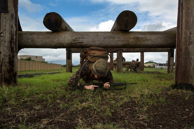 Cpl. Matthew Ochs, a field radio operator with Headquarters Company, 3rd Marine Regiment, low crawls under some of the obstacles during a training exercise on the obstacle course at Boondocker Training Area aboard Marine Corps Base Hawaii, Feb. 25, 2014. The Marines were participating in Corporals Course and completed a case study that took them through several training exercises based off true scenarios Gunnery Sgt. Timothy C. Tardif experienced during Operation Iraqi Freedom, April 12, 2003. Three squad-sized teams participated in a leadership reaction course, and exercises at Boondocker Training Area to include the obstacle course and military operations on urban terrain facility and a 100-meter swim at the base pool. At the conclusion of the case study, the Marine gathered at Dewey Square to listen to Tardif explain the challenges he faced as a corporal on the battlefield and how he overcame them.  (U.S. Marine Corps photo by Lance Cpl. Matthew Bragg)