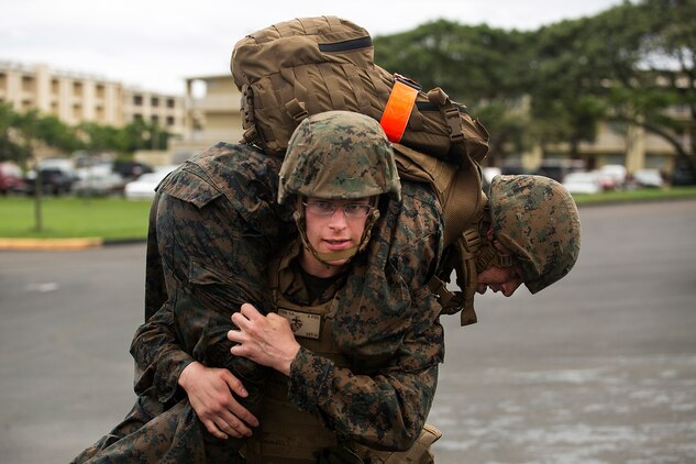 Cpl. Sean Stein, an operator with 3rd Radio Battalion, fireman carries an “incapacitated” Marine to Dewey Square after completing a 100-meter swim at the base pool aboard Marine Corps Base Hawaii, Feb. 25, 2014. The Marines were participating in Corporals Course and completed a case study that took them through several training exercises based off true scenarios Gunnery Sgt. Timothy C. Tardif experienced during Operation Iraqi Freedom, April 12, 2003. Three squad-sized teams participated in a leadership reaction course, and exercises at Boondocker Training Area to include the obstacle course and military operations on urban terrain facility and a 100-meter swim at the base pool. At the conclusion of the case study, the Marine gathered at Dewey Square to listen to Tardif explain the challenges he faced as a corporal on the battlefield and how he overcame them. (U.S. Marine Corps photo by Lance Cpl. Matthew Bragg)