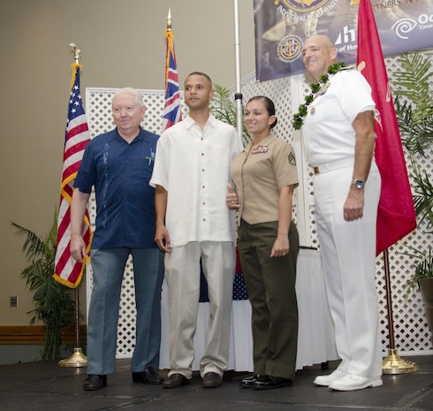 HONOLULU — Staff Sgt. Michelle Milan, the custodian of postal effects at the base post office and native of San Francisco, along with her fiancé, pose for a photo with Honolulu Navy League president Carl Devoe (left) and Rear Adm. Robert P. Girrier, the deputy commander of the U.S. Pacific Fleet (right), Honolulu Navy League’s Boots on the Ground 2014 Individual Augmentee Recognition Luncheon at the Ala Moana Hotel, Feb. 21, 2014. The league will no longer host the IA luncheon after this year, until there are IAs serving again. (U.S. Marine Corps photo by Kristen Wong)