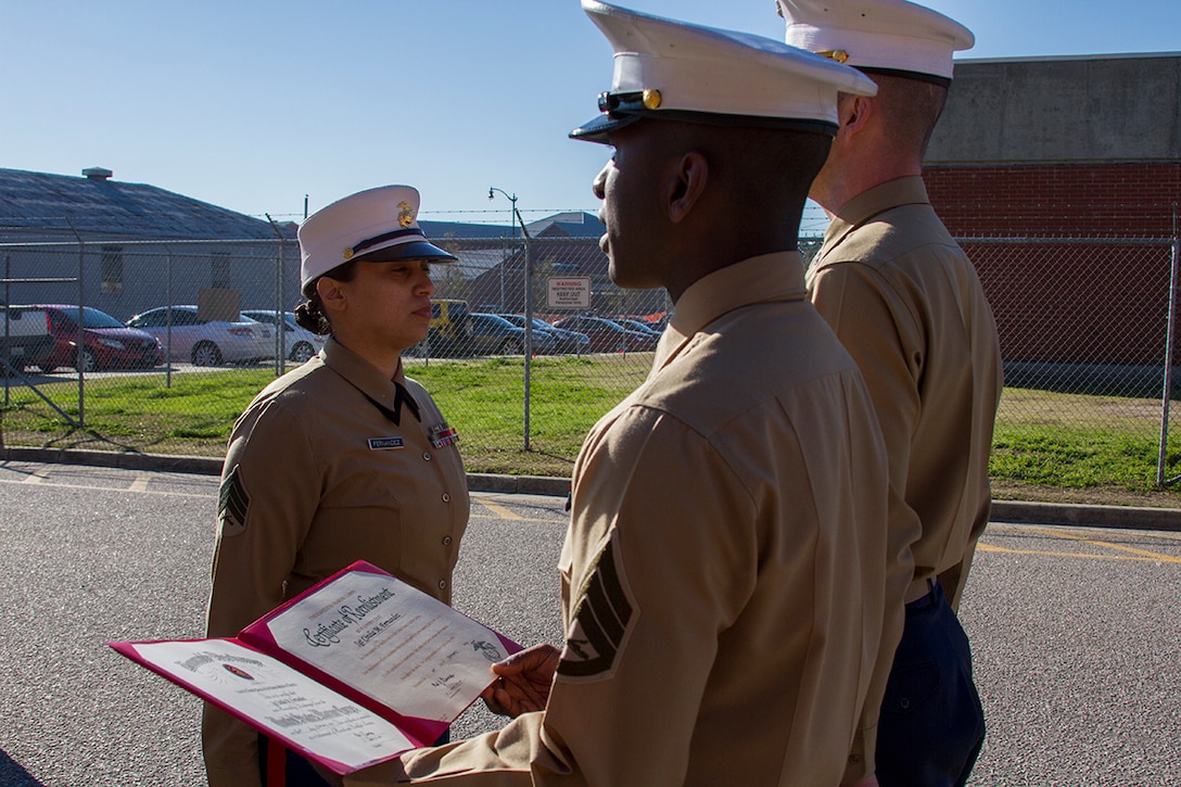 MARINE CORPS RECRUIT DEPOT PARRIS ISLAND, S.C. - Sgt. Cindia Fernandez, 6th Marine Corps District Administrative Chief, stands in front of CWO3 Jeremiah Elsbury, 6MCD Personnel Officer, and Staff Sgt. Alfred Kennard, 6MCD Career Planner, during her reenlistment ceremony on Parris Island’s famed yellow footprints, here, on Feb. 28, 2014. Fernandez is scheduled to move to Atlanta in June, where she will take over as the administrative chief for Recruiting Station Atlanta. (Official Marine Corps photo by Lance Cpl. John-Paul Imbody)