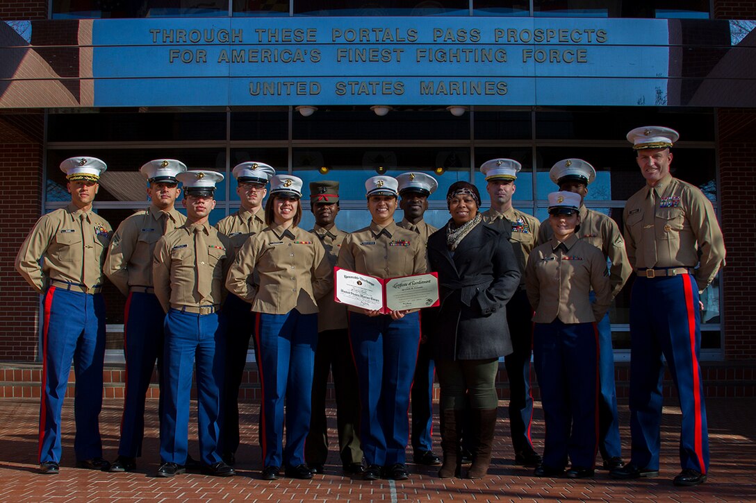 MARINE CORPS RECRUIT DEPOT PARRIS ISLAND, S.C. - Sgt. Cindia Fernandez, 6th Marine Corps District Administrative Chief (center), poses for a group photo after reenlisting for four additional years in the Marine Corps, here, on Feb. 28, 2014. Fernandez is scheduled to move to Atlanta in June, where she will take over as the administrative chief for Recruiting Station Atlanta. (Official Marine Corps photo by Lance Cpl. John-Paul Imbody)