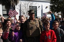 Petty Officer Third Class Justin Phares, a corpsman with 2nd Medical Battalion, 2nd Marine Logistics Group poses for photos with students outside of Carolina Beach Elementary School during a hike through Carolina Beach, N.C., with 2nd Maintenance Bn. Feb. 27, 2014.  The students made signs, held American flags and cheered the Marines and sailors on their way to Fort Fisher. (U.S. Marine Corps photo by Lance Cpl. Shawn Valosin)