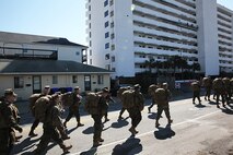 Marines and sailors with 2nd Maintenance Battalion, Combat Logistics Regiment 25, 2nd Marine Logistics Group hike through residential streets in Carolina Beach, N.C., Feb. 27, 2014 while making their way to Fort Fisher. Marines and sailors with the company hiked with approximately 70 pounds of gear at a pace of three miles per hour, stopping at historical locations for professional military education lectures. (U.S. Marine Corps photo by Lance Cpl. Shawn Valosin)