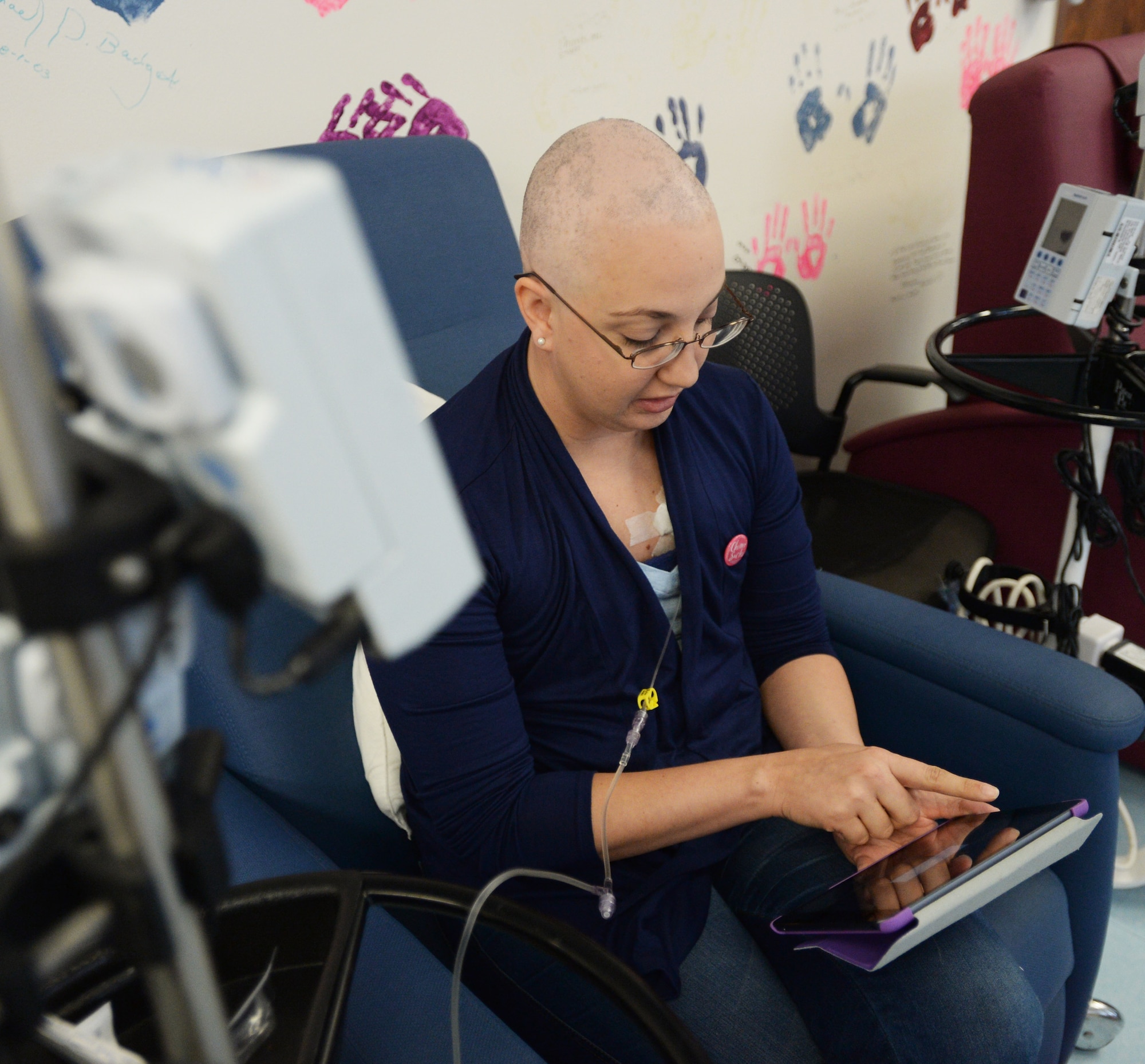 Staff Sgt. Amanda Dick, 15th Medical Support Squadron patient flight, reads an eBook during her chemotherapy treatment at Tripler Army Medical Center, Honolulu, Hawaii, Feb. 26, 2014. Since being diagnosed with breast cancer in October 2013, Dick has finished one-of-two rounds of chemotherapy, and is expected to be done with treatment in April. (U.S. Air Force photo/Staff Sgt. Alexander Martinez)