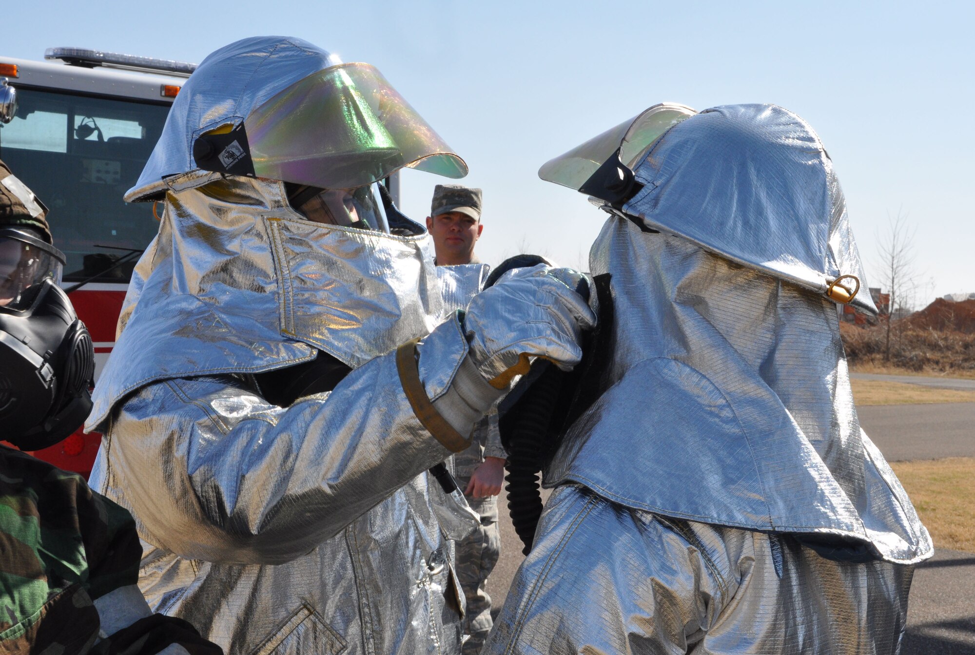 Tech. Sgt. Scott Lair, 507th Civil Engineer Squadron observes students don the Joint Firefighter's Integrated Response Ensemble during the Unit Training Assembly here 28 Feb. (U.S. Air Force Photo/Maj. Jon Quinlan)