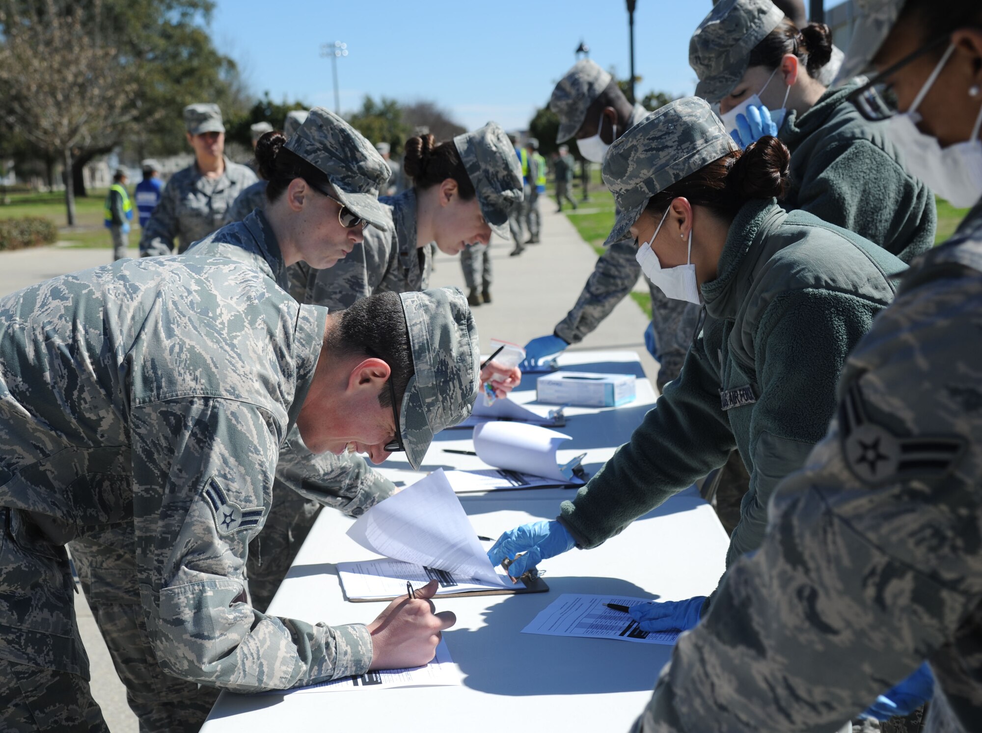 Airman 1st Class Stephan Coleman, 81st Training Wing, completes a ‘patient’ form as he processes through the patient administration line during a disease containment plan and point of dispensing exercise Feb. 27, 2014, at the Vandenberg Community Center, Keesler Air Force Base, Miss. The scenario included a steep rise in the number of patients with flu-like symptoms and the medical group distributing large quantities of influenza medications and vaccinations. (U.S. Air Force photo by Kemberly Groue)