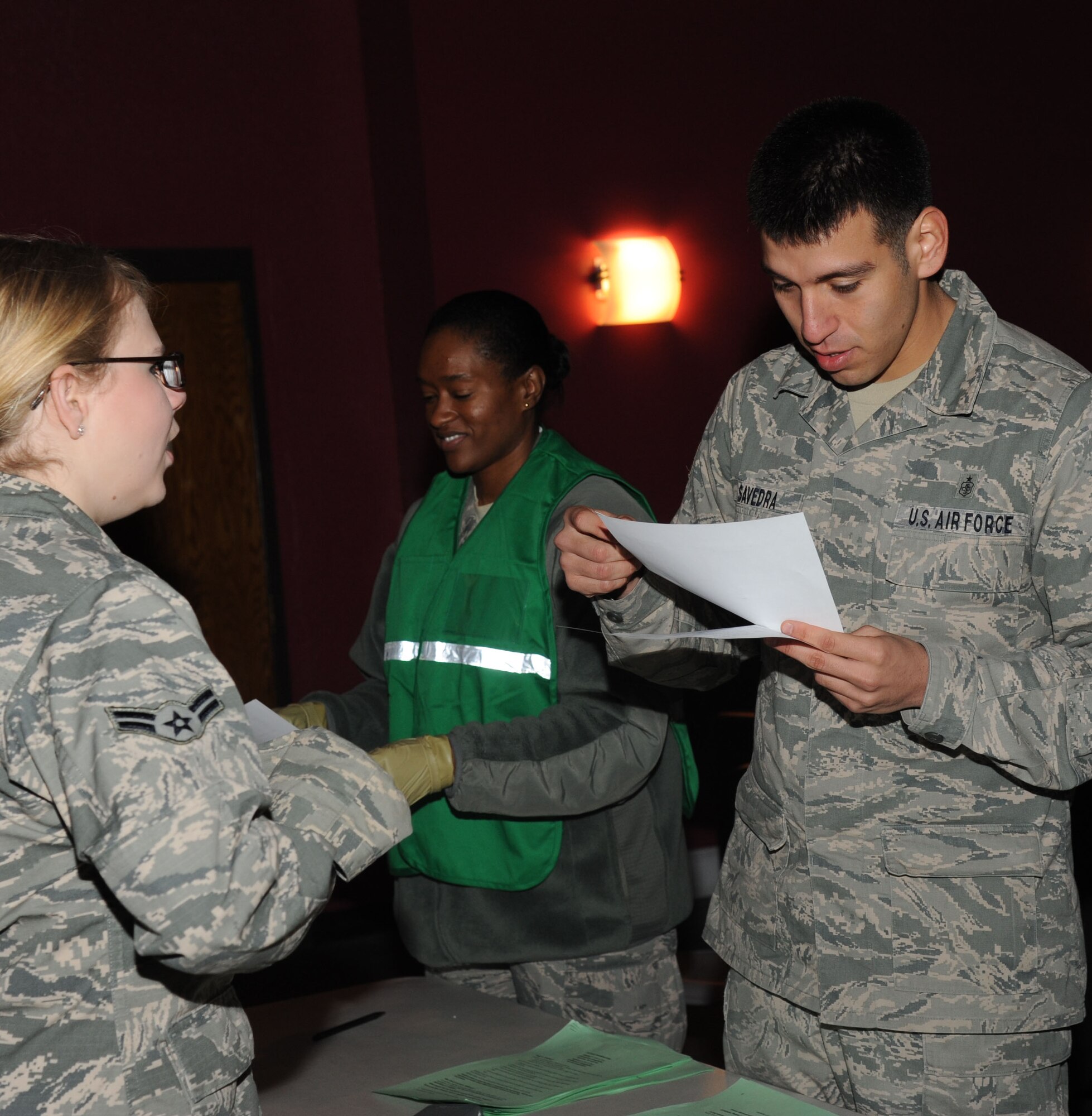 Airman 1st Class Katryn Booth, 81st Aerospace Medicine Squadron, serves as a ‘patient’ receiving medication from Staff Sgts. Janee Relaford and Allen Savedra, 81st Diagnostic and Therapeutics Squadron, as she goes through the make-shift pharmacy inside the Vandenberg Community Center during a disease containment plan and point of dispensing exercise Feb. 27, 2014, at Keesler Air Force Base, Miss. The scenario included a steep rise in the number of patients with flu-like symptoms and the medical group distributing large quantities of influenza medications and vaccinations.  (U.S. Air Force photo by Kemberly Groue)