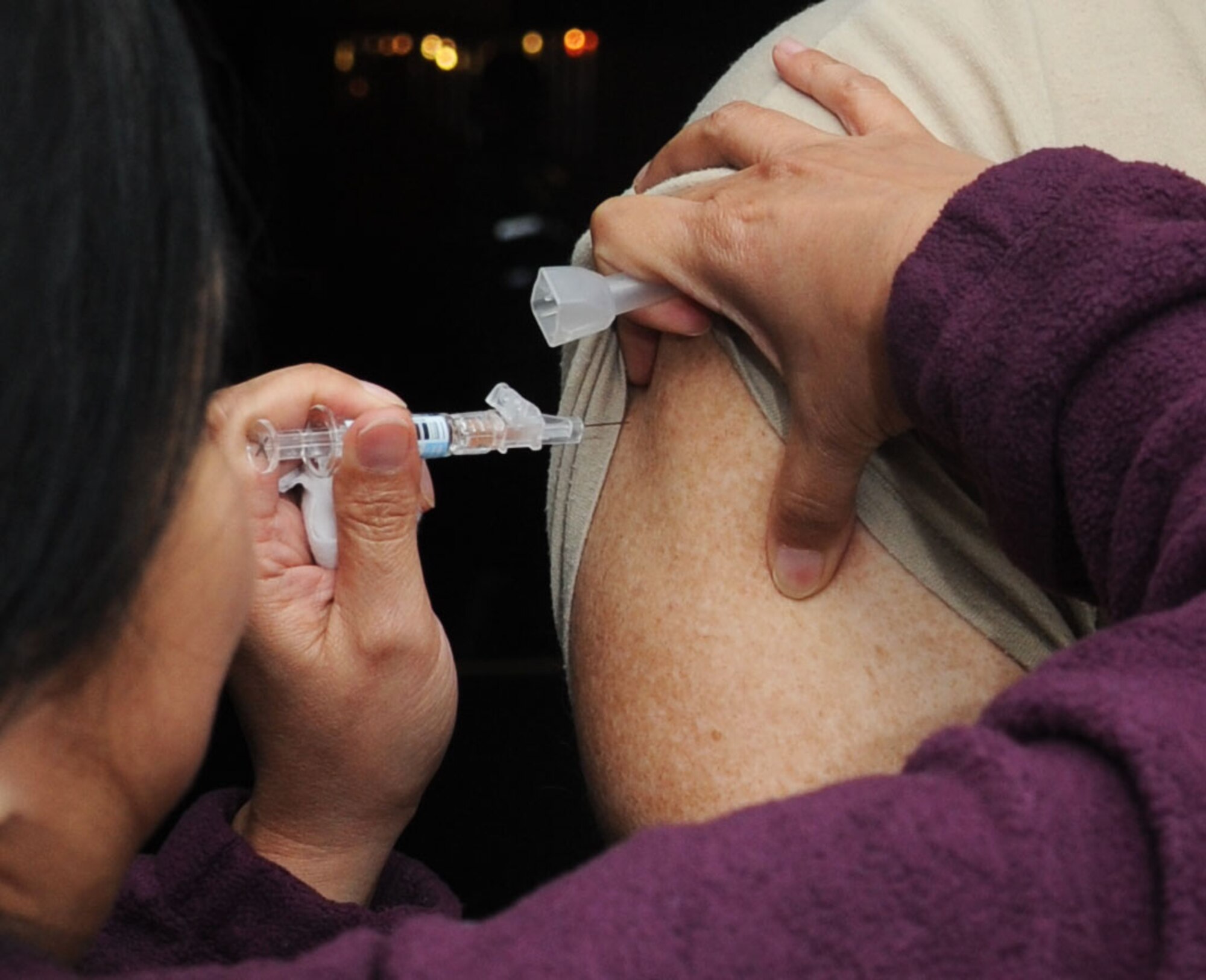 Helen Vandergrinten, 81st Medical Operations Squadron, administers a flu shot to Maj. Michael Renkas, 81st Aerospace Medicine Squadron, during a disease containment plan and point of dispensing exercise Feb. 27, 2014, at the Vandenberg Community Center, Keesler Air Force Base, Miss. The scenario included a steep rise in the number of patients with flu-like symptoms and the medical group distributing large quantities of influenza medications and vaccinations.  (U.S. Air Force photo by Kemberly Groue)