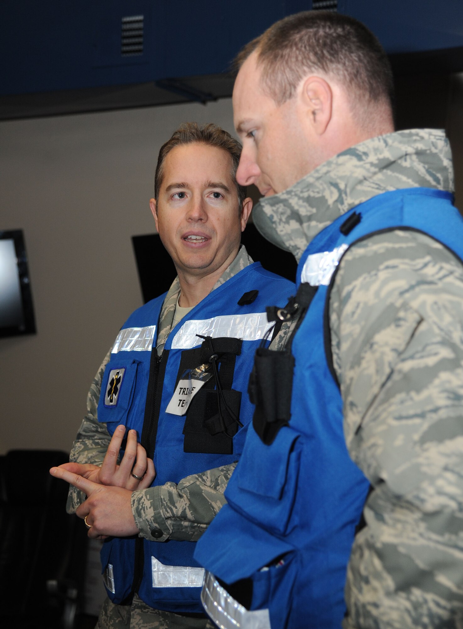 Majors Dana Jensen and Stephen Gasparovich, 81st Dental Squadron, discuss a patient situation as they serve as triage team members during a disease containment plan and point of dispensing exercise Feb. 27, 2014, at the Vandenberg Community Center, Keesler Air Force Base, Miss. The scenario included a steep rise in the number of patients with flu-like symptoms and the medical group distributing large quantities of influenza medications and vaccinations.  (U.S. Air Force photo by Kemberly Groue)