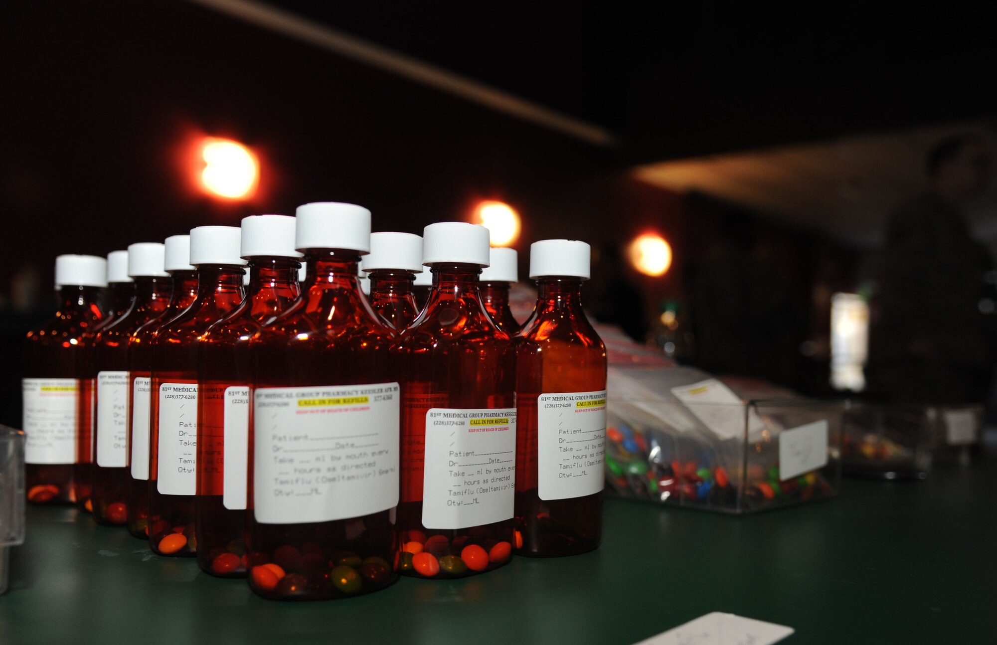 Bottles of ‘medication’ sit on a table for dispensing to patients as they move through the makeshift pharmacy inside the Vandenberg Community Center during a disease containment plan and point of dispensing exercise Feb. 27, 2014, at Keesler Air Force Base, Miss. The scenario included a steep rise in the number of patients with flu-like symptoms and the medical group distributing large quantities of influenza medications and vaccinations.  (U.S. Air Force photo by Kemberly Groue)