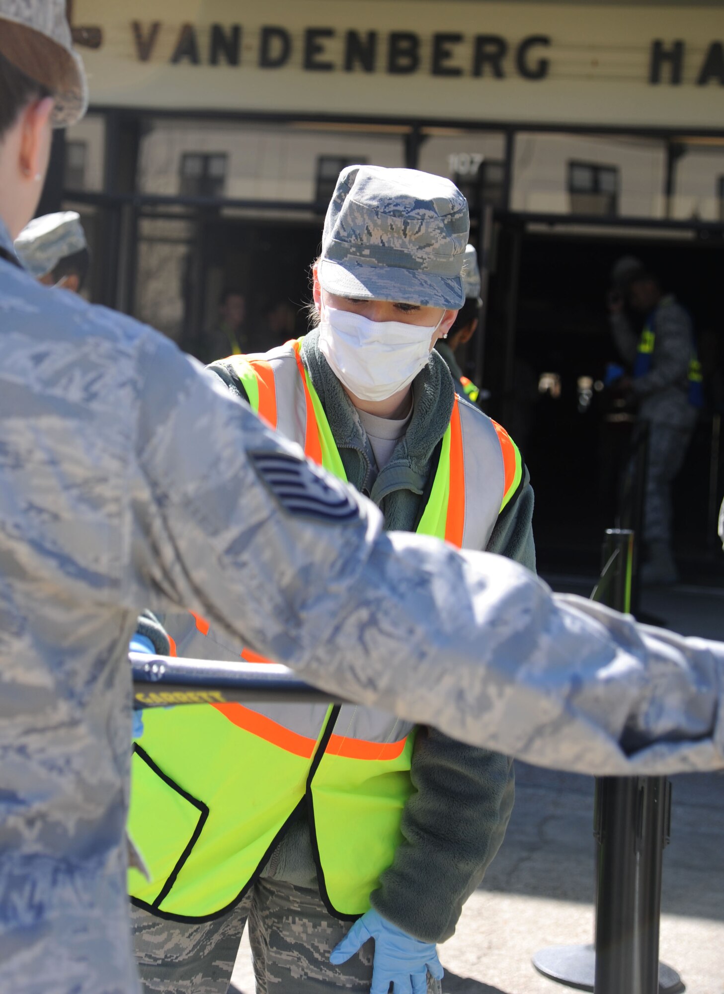Senior Airman Madison Rossi, 81st Dental Squadron, uses a metal detector to scan a ‘patient’, Tech. Sgt. YoLanda Quinlivan, 81st Surgical Operations Squadron, before entering the Vandenberg Community Center to receive medication during a disease containment plan and point of dispensing exercise Feb. 27, 2014, at Keesler Air Force Base, Miss. The scenario included a steep rise in the number of patients with flu-like symptoms and the medical group distributing large quantities of influenza medications and vaccinations.  (U.S. Air Force photo by Kemberly Groue)