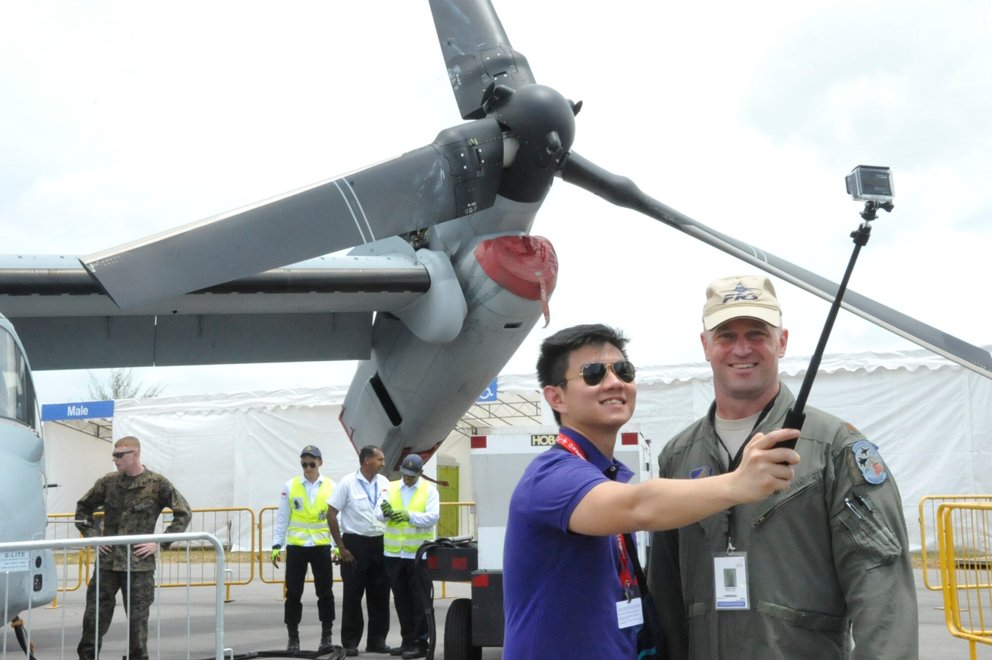 Major Dixon Croft, detachment commander of the 497th Combat Training Flight in Singapore poses with a visitor in front of an MV-22 Osprey at the 2014 Singapore International Airshow, Feb. 13, 2014. The U.S. continues to demonstrate its commitment to maintaining peace and stability in the Asia-Pacific region by participating in events such as airshows and exercises with partner nations. (U.S. Air Force photo/Capt. Tamara Fischer-Carter)