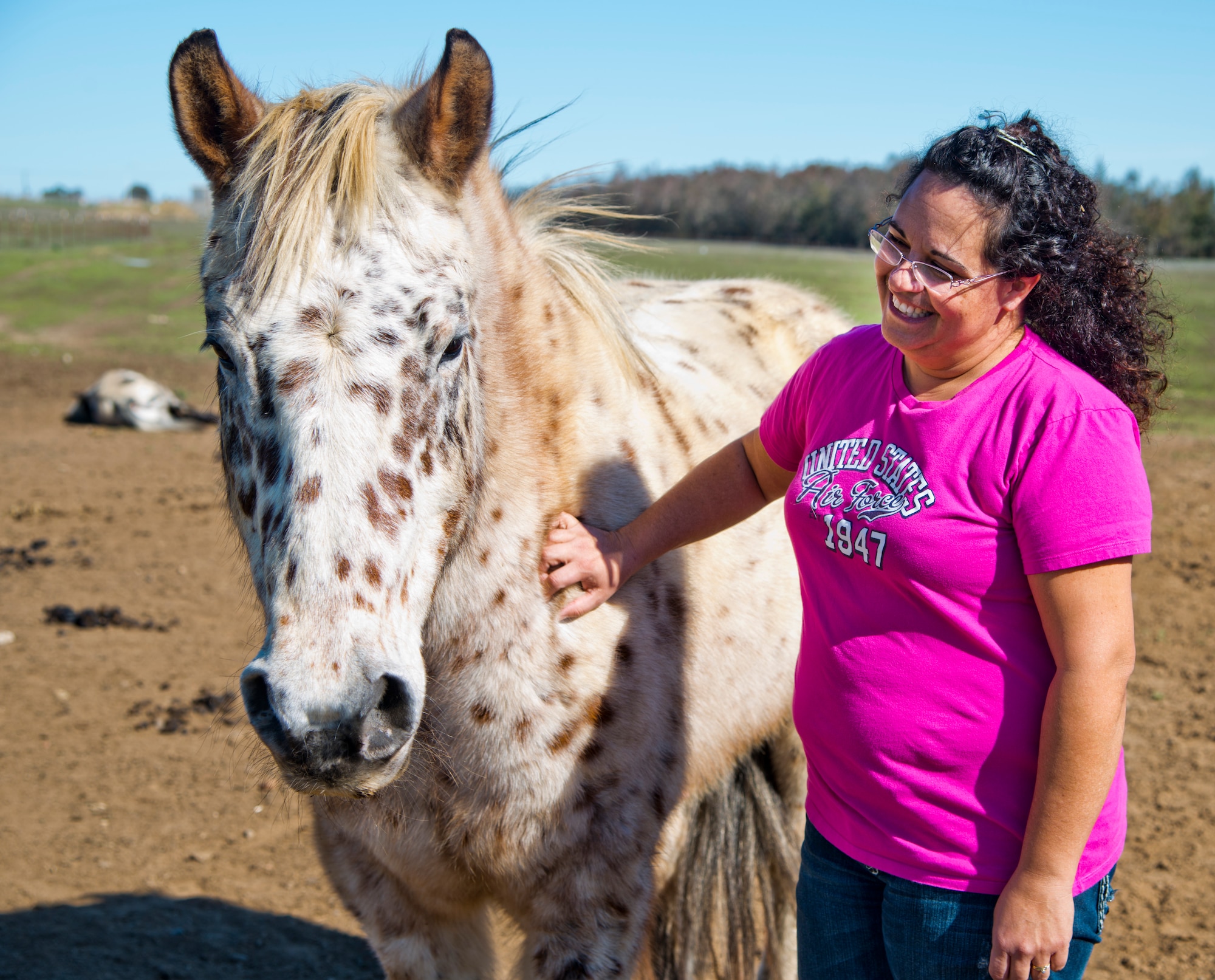 Kristine Moyer, 60th Force Support Squadron equestrian center volunteer worker, greets one of the horses in the free-range pastures on base Feb. 19. The Travis Equestrian Center has more than 200 acres of land for the horses to roam. (U.S. Air Force photo/Senior Airman Nicole Leidholm)