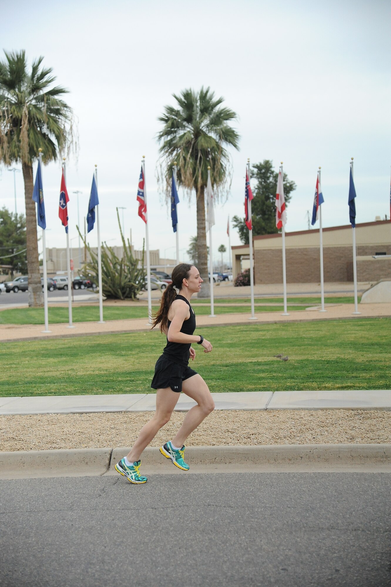 Airman 1st Class Melissa Franks, 56th Medical Operations Squadron medical technician, runs past the F-16 display outside wing headquarters Monday after completing a six-mile run. Franks has aspirations of competing with the Air Force cross-country team. (U.S. Air Force photo/Airman 1st Class Pedro Mota)