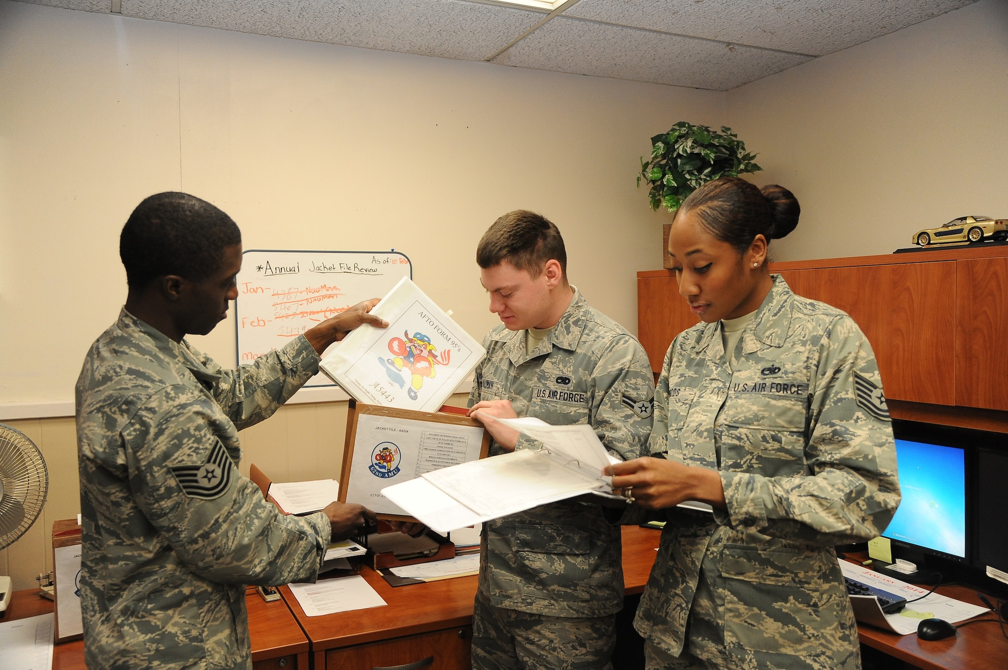 FROM LEFT: Tech. Sgt. Malcolm Samuel, 56th Maintenance Group section chief, Airman 1st Class Mathew Nauman, 56th Maintenance Squadron aircraft maintenance scheduler, and Tech. Sgt. Kyla Woods, 308th Aircraft Maintenance Unit NCO in charge, perform an annual jacket file inspection Feb. 18 at Luke Air Force Base. The jacket file holds the historical records of the parts and maintenance activities on a particular jet.  (U.S. Air Force photo/Airman 1st Class Pedro Mota)