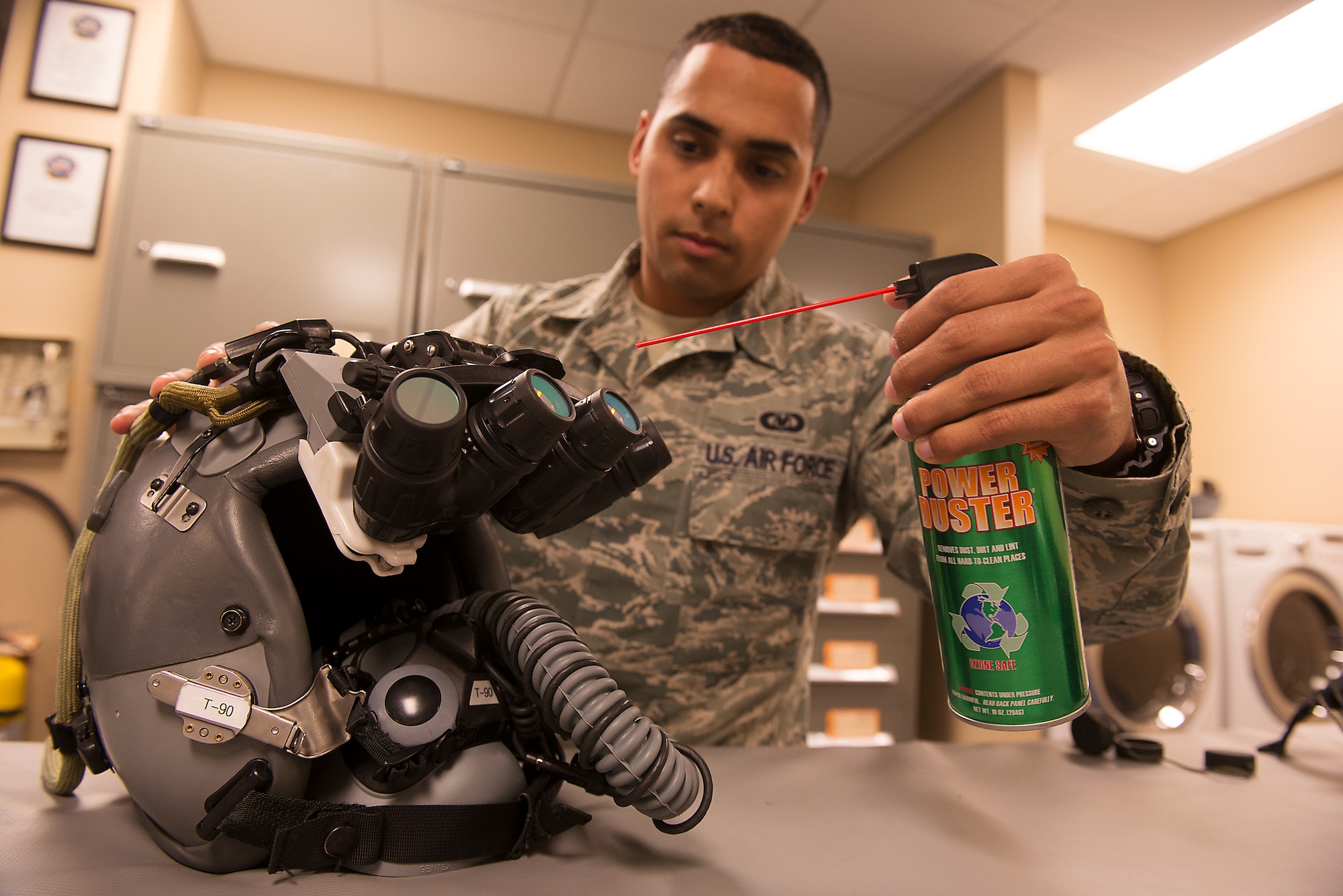 U.S. Air Force Senior Airman Jairo Diaz, 23d Operations Support Squadron aircrew flight equipment technician, sprays air on panoramic night vision goggles during a post-flight inspection at Moody Air Force Base, Ga., Feb. 27, 2014. The goggles are inspected for any cuts, scrapes, smudges or malfunctions before and after each flight. Inspectors must have 20/20 vision to ensure the PNVGs are inspected properly. (U.S. Air Force photo by Senior Airman Tiffany M. Grigg/Released) 