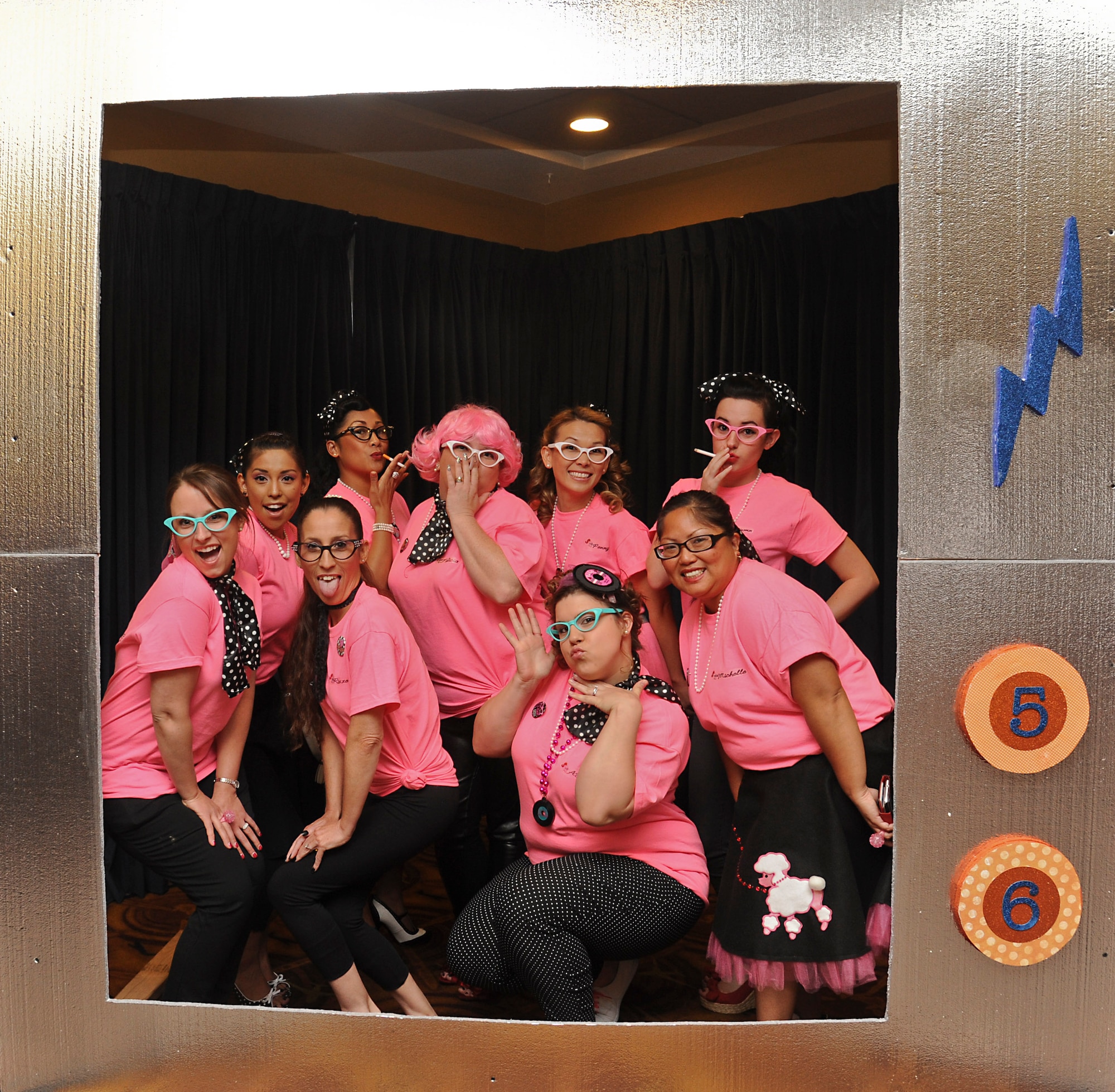56th Civil Engineer Squadron spouses pose in a TV frame set up for photos at the Spouses Dining In Saturday at Club Five Six. CES spouses dressed as the Pink Ladies from the movie “Grease.”  (U.S. Air Force photo/Staff Sgt. Darlene Seltmann)