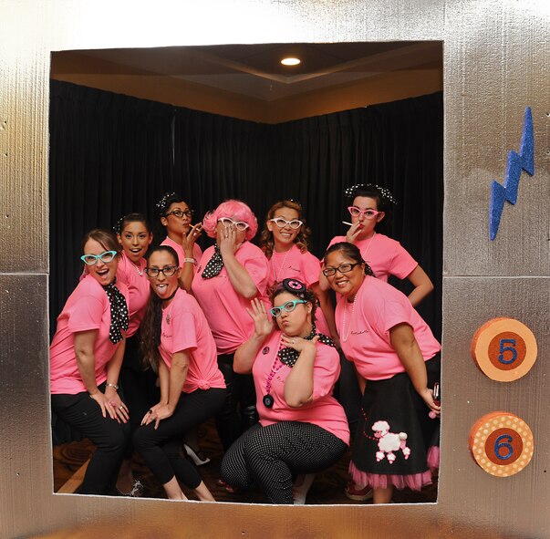 56th Civil Engineer Squadron spouses pose in a TV frame set up for photos at the Spouses Dining In Saturday at Club Five Six. CES spouses dressed as the Pink Ladies from the movie “Grease.”  (U.S. Air Force photo/Staff Sgt. Darlene Seltmann)
