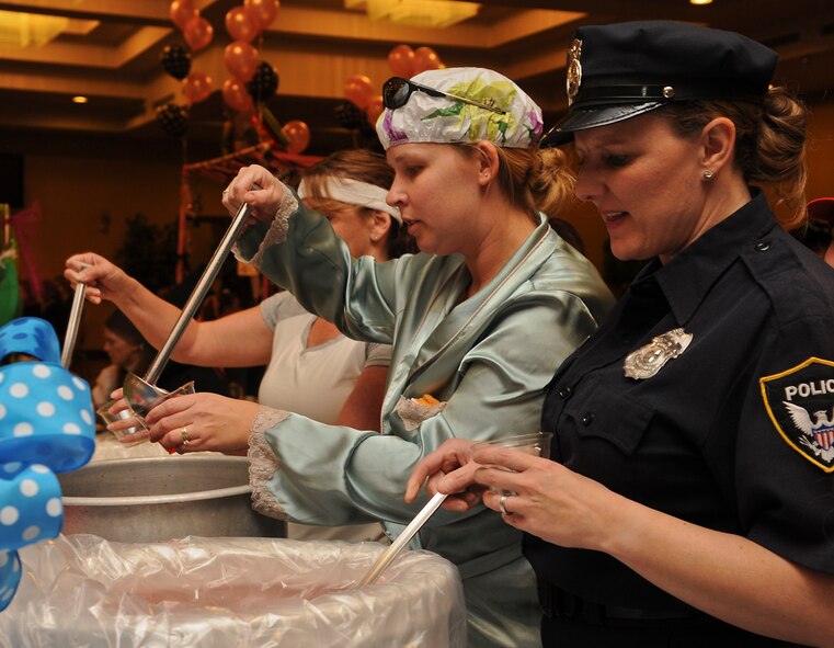 56th Security Forces Squadron spouses fill glasses with grog. The spouses were sent to the grog bowl for improperly leaving the event.  (U.S. Air Force photo/Staff Sgt. Darlene Seltmann)