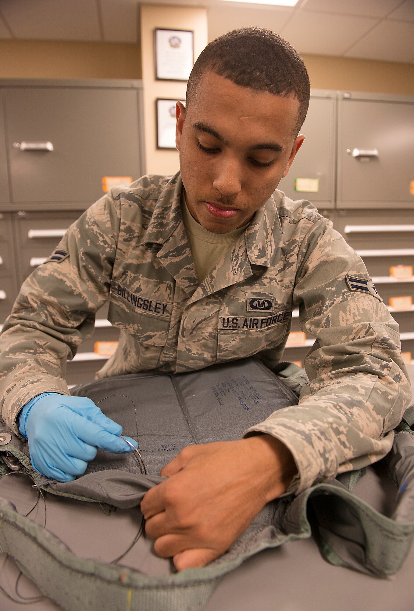U.S. Air Force Airman 1st Class Islen Billingsley, 23d Operations Support Squadron aircrew flight equipment technician, attaches a personnel lowering device to a torso harness at Moody Air Force Base, Ga., Feb. 27, 2014. These AFE Airmen support the 74th, 75th and 76th Fighter Squadrons. (U.S. Air Force photo by Senior Airman Tiffany M. Grigg/Released) 