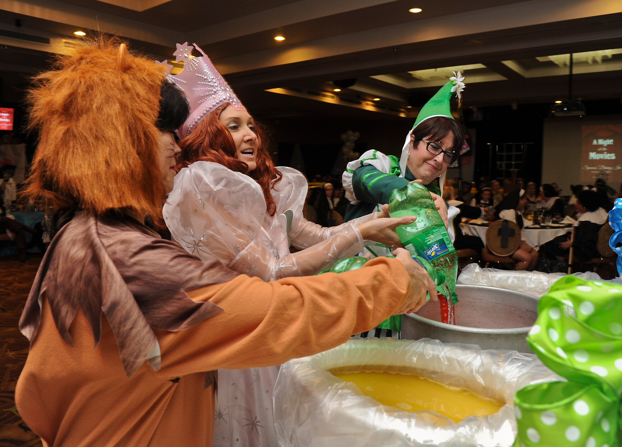Fighter Country Partnership members pour the makings of grog into the bowls during the Spouses Dining In. They dressed as characters from “The Wizard of Oz.”  (U.S. Air Force photo/Staff Sgt. Darlene Seltmann)