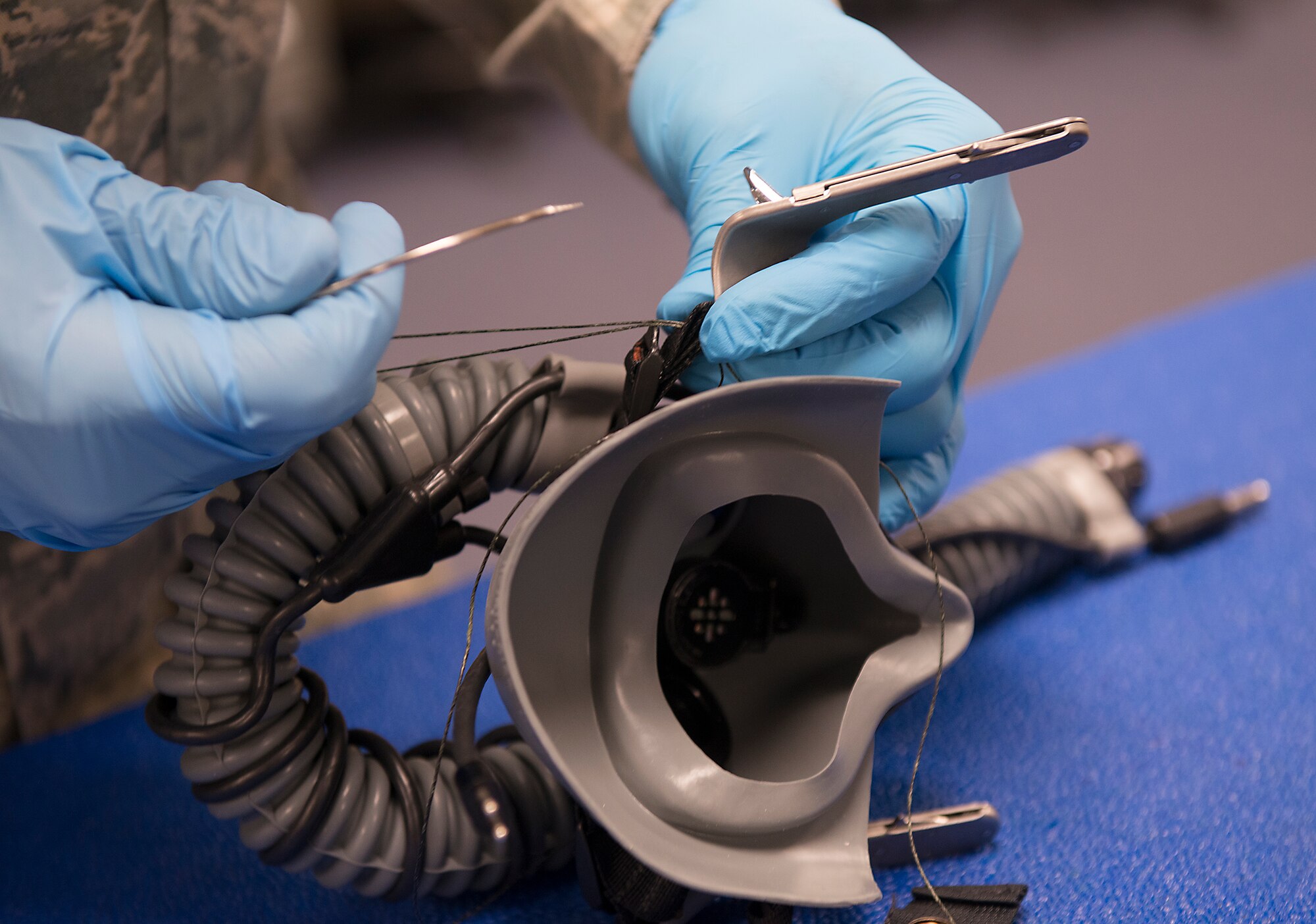 U.S. Air Force Senior Airman Dieri Dieujuste, 23d Operations Support Squadron aircrew flight equipment technician, tacks a combat edge oxygen mask at Moody Air Force Base, Ga., Feb. 27, 2014. This process includes re-fitting the mask, adjusting all straps and ensuring serviceability. (U.S. Air Force photo by Senior Airman Tiffany M. Grigg/Released) 