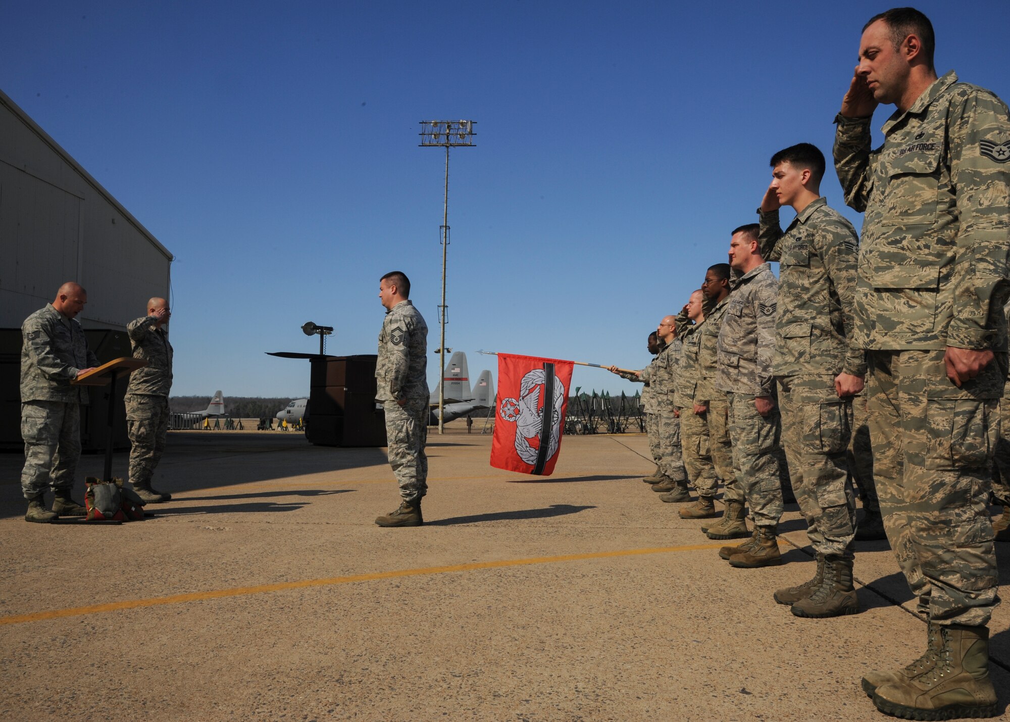 The 19th Logistics Readiness Squadron aerial porters salute while the names of fallen comrades are read by Tech Sgt. Kevin Gibson, 19th Logistics Readiness Squadron aircraft services noncommissioned officer-in-charge, Feb. 21, 2014, at Little Rock Air Force Base, Ark. The Airmen followed the salute with a 3K run along the flightline to honor the troops. (U.S. Air Force photo by Airman 1st Class Harry Brexel)