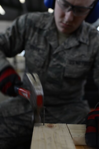 U.S. Air Force Airman 1st Class Frank Houdek, 52nd Logistics Readiness Squadron packing and crating specialist from Tucson, Ariz., hammers down the edges of a crate at Spangdahlem Air Base, Germany, Feb. 25, 2014. Traffic Management Office Airmen process and ship supplies ranging from nuts and bolts to aircraft wheels through their office every day. (U.S. Air Force photo by Senior Airman Gustavo Castillo/Released) 