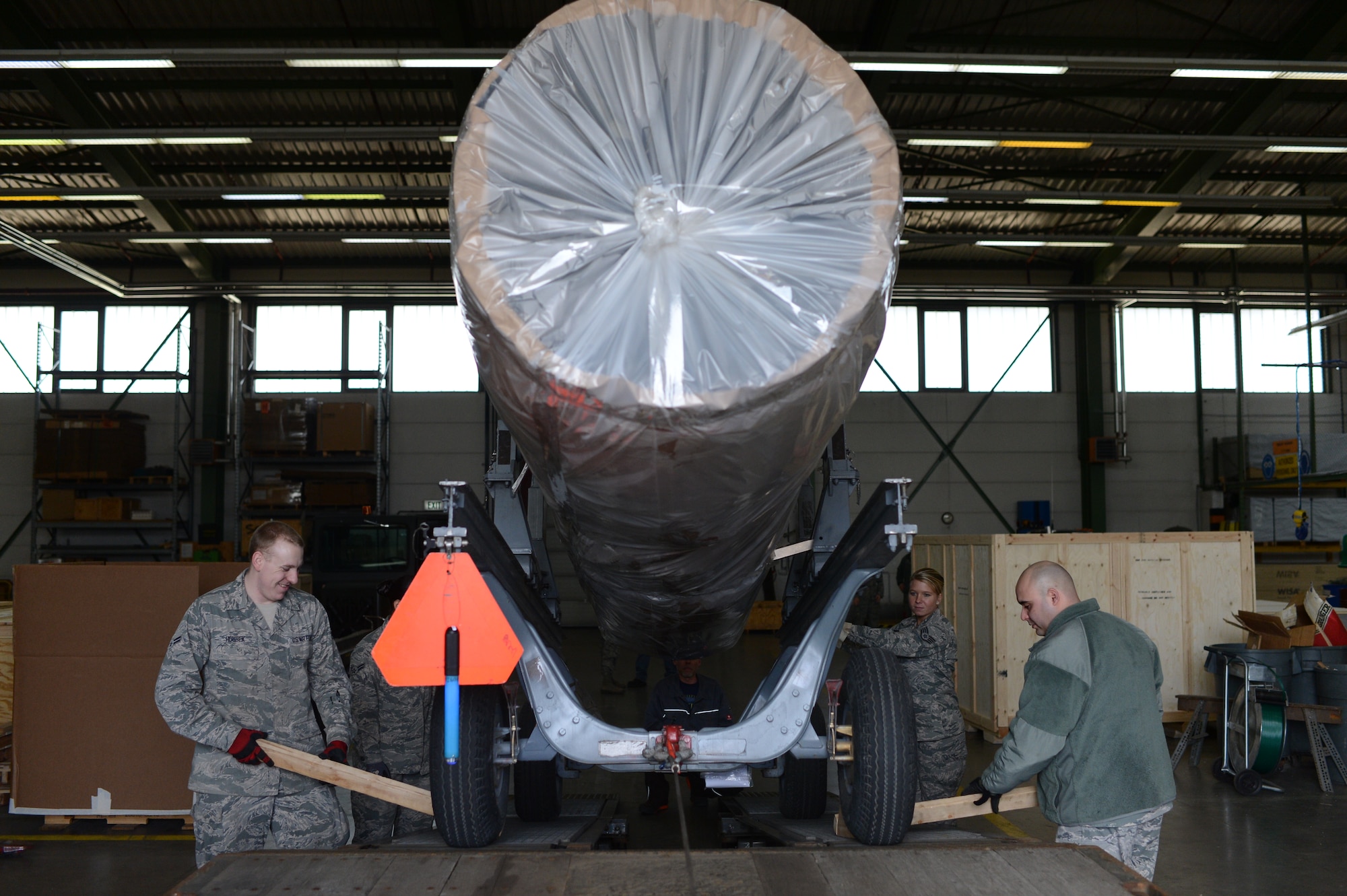 Airmen from the 52nd Logistics Readiness Squadron load the engine of an F-16 Fighting Falcon fighter aircraft on the bed of a truck at Spangdahlem Air Base, Germany, Feb. 25, 2014. Airmen from the 52nd LRS ship engines all around the world for both equipment rehabilitation and mission support. (U.S. Air Force photo by Senior Airman Gustavo Castillo/Released)