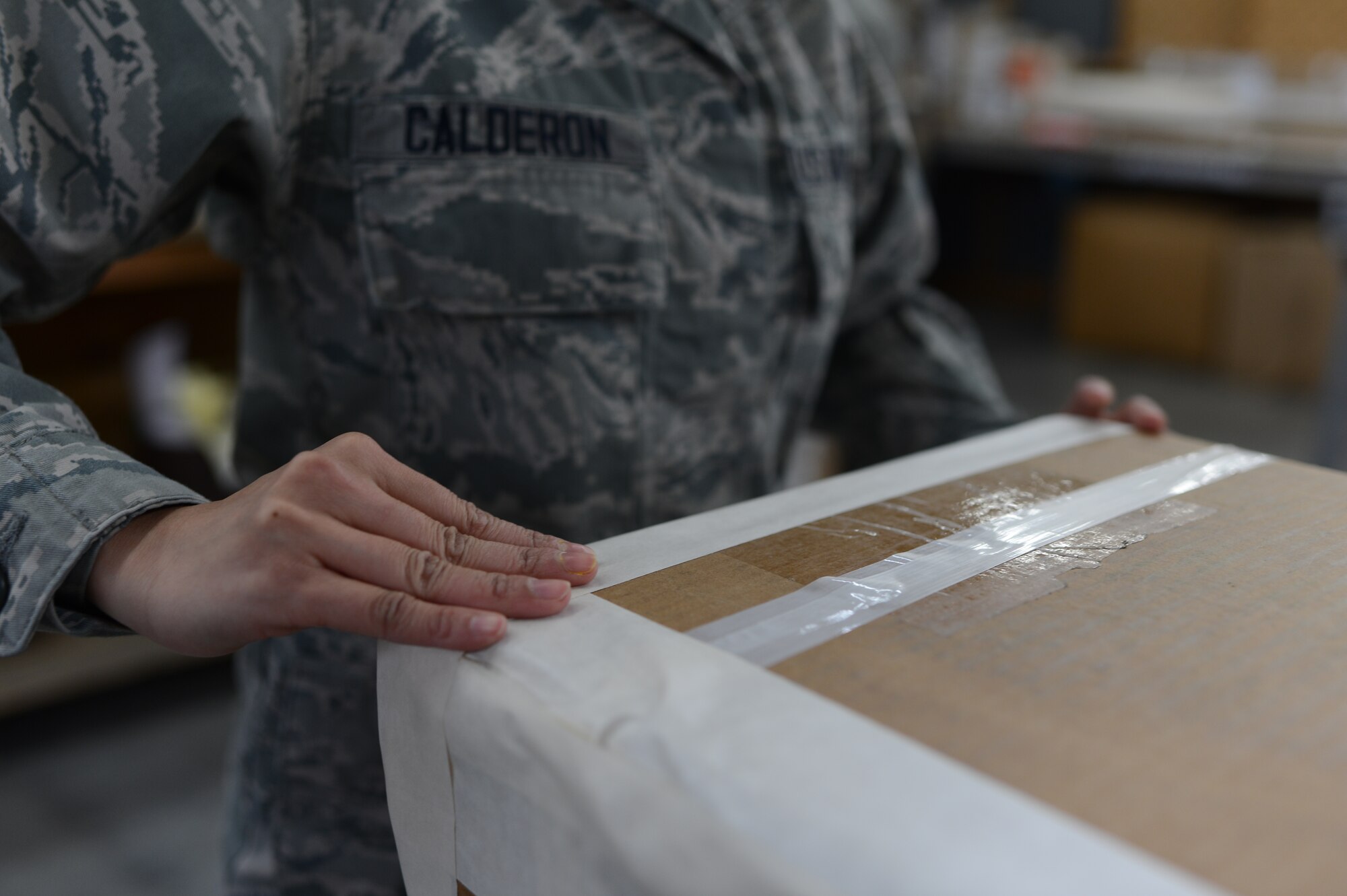 U.S. Air Force Airman 1st Class Eryn Calderon, 52nd Logistics Readiness Squadron packing and crating specialist from Colorado Springs, Colo., tapes the edges of a package at Spangdahlem Air Base, Germany, Feb. 25, 2014. The Traffic Management Office sends out more than 100 packages of a plethora of items every week. (U.S. Air Force photo by Senior Airman Gustavo Castillo/Released) 