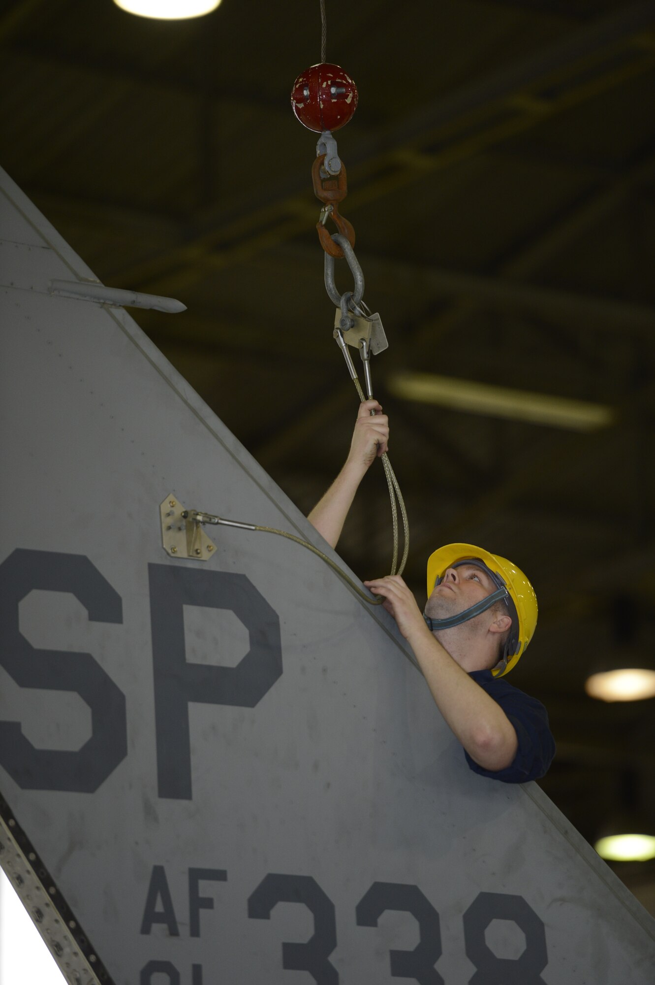 U.S. Air Force Tech. Sgt. Matthew Szrejter, 52nd Equipment Maintenance Squadron F-16 phase dock chief, from Boynton Beach Fla., mounts a sky hook crane on the vertical stabilizer on an F-16 Fighting Falcon on Spangdahlem Air Base, Germany Feb. 25, 2014. Aircraft are inspected on a flight hours basis ranging from 400 to 2400 hour rotations. (U.S. Air Force photo by Staff Sgt. Christopher Ruano/Released)