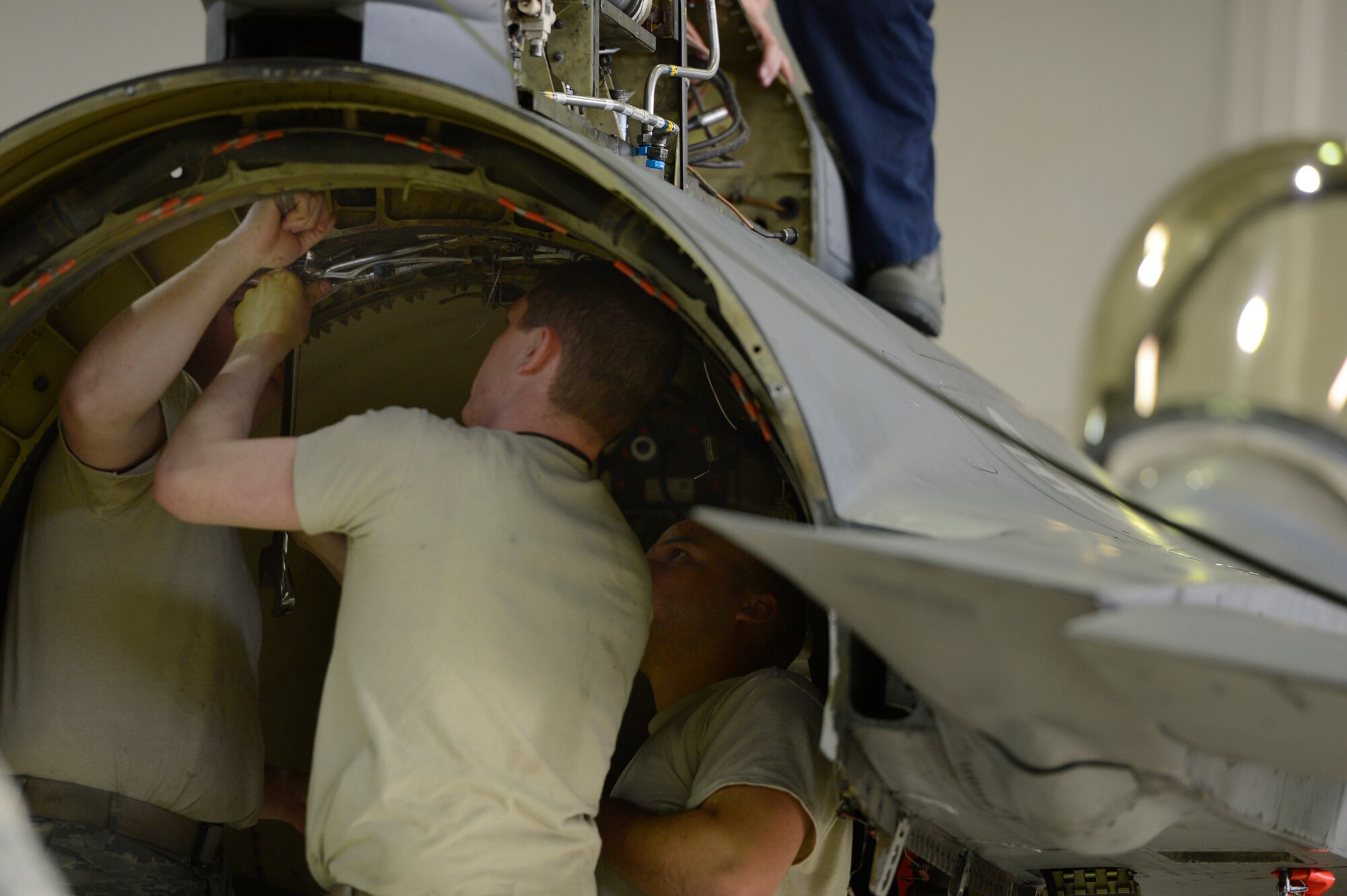 Members of the 52nd Equipment Maintenance Squadron work together to unscrew bolts off of a F-16 Fighting Falcon vertical stabilizer Feb. 25, 2014 at Spangdahlem Air Base, Germany. The vertical stabilizer of the F-16 Fighting Falcon was removed in order to make repairs to aircraft brackets. (U.S. Air Force photo by Staff Sgt. Christopher Ruano/Released)