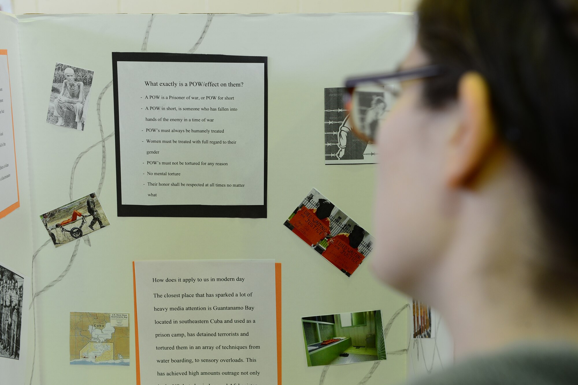 A judge reviews a prisoner of war exhibit during the third annual National History Day event at Lakenheath High School gym on Royal Air Force Lakenheath, England, Feb. 27, 2014. There were a total of 125 students from six different schools participating in the contest. (U.S. Air Force photo by Airman 1st Class Dawn M. Weber/ Released)