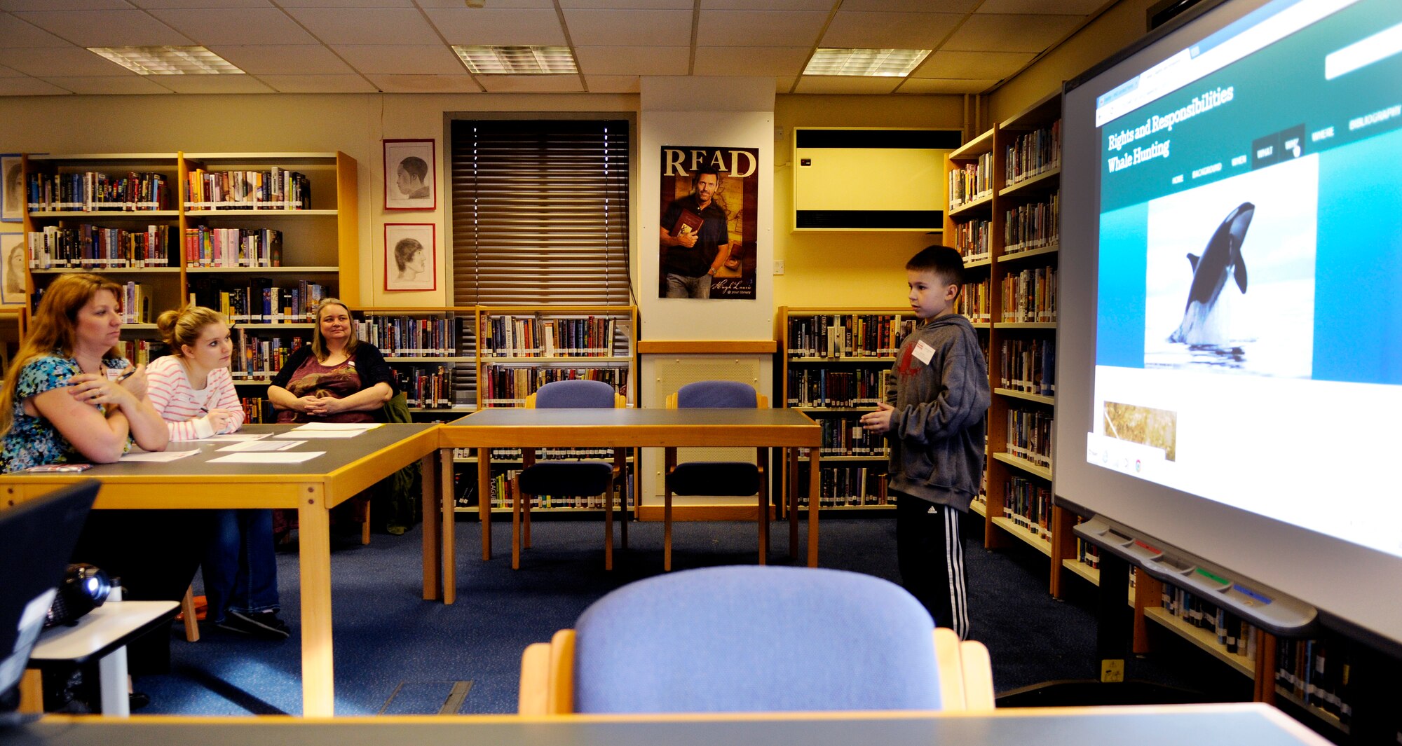 Cody Routh (right), gives a presentation during the third annual National History Day contest at Lakenheath High School, on Royal Air Force Lakenheath, England, Feb. 27, 2014. Students prepared their projects according to broad themes that are left to them to interpret. This year’s theme was “rights and responsibilities”. (U.S. Air Force photo by Staff Sgt. Emerson Nuñez/Released)