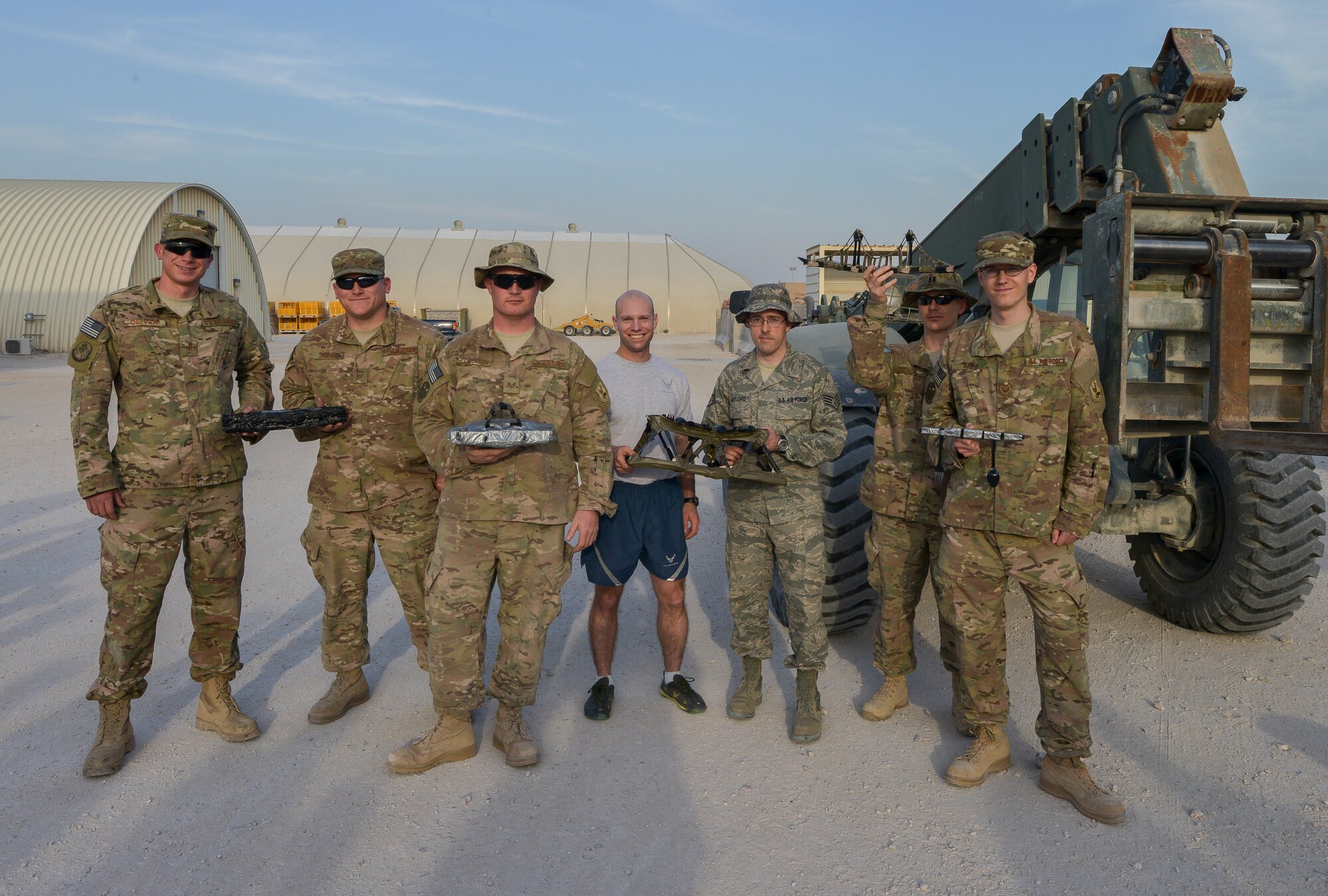 Civil engineer Airmen pose with model-sized bridges at Al Udeid Air Base, Qatar, Feb. 22, 2014, during a bridge building competition to celebrate National Engineer Week. National Engineer week, which ran from Feb. 16 – 22 this year, was started in 1951 to highlight the accomplishments of historical engineer features, people and how engineers have made a great impact on today’s society. Airmen from the 379th Expeditionary Civil Engineer Squadron, 577th Expeditionary Prime Base Engineer Emergency Force Squadron, and the 557th Expeditionary Rapid Deployable Heavy Operational Repair Squadron Engineer Squadron who construct buildings, runways, bridges and roads throughout the Air Forces Central Command area of responsibility, participated in the event. (U.S. Air Force photo/Senior Airman Jared Trimarchi) 