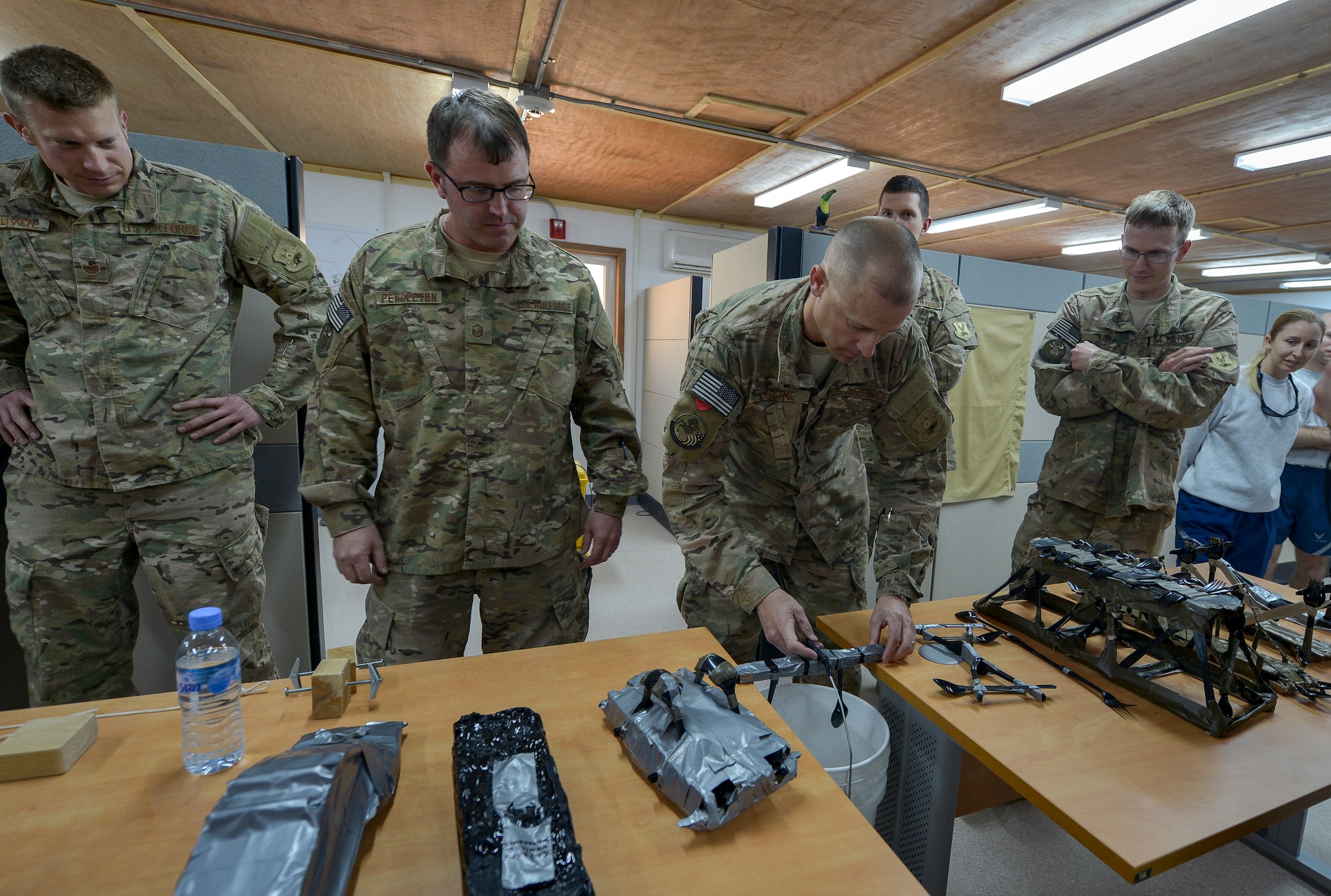 Civil engineer Airmen watch as weight is being applied to a model-sized bridge at Al Udeid Air Base, Qatar, Feb. 22, 2014, during a bridge building competition to celebrate National Engineer Week. National Engineer week, which ran from Feb. 16 – 22 this year, and was started in 1951 to highlight the accomplishments of historical engineer features, people and how engineers have made a great impact on today’s society. Airmen from the 379th Expeditionary Civil Engineer Squadron, 577th Expeditionary Prime Base Engineer Emergency Force Squadron, and the 557th Expeditionary Rapid Deployable Heavy Operational Repair Squadron Engineer Squadron who construct buildings, runways, bridges and roads throughout the Air Forces Central Command area of responsibility, participated in the event. (U.S. Air Force photo/Senior Airman Jared Trimarchi) 