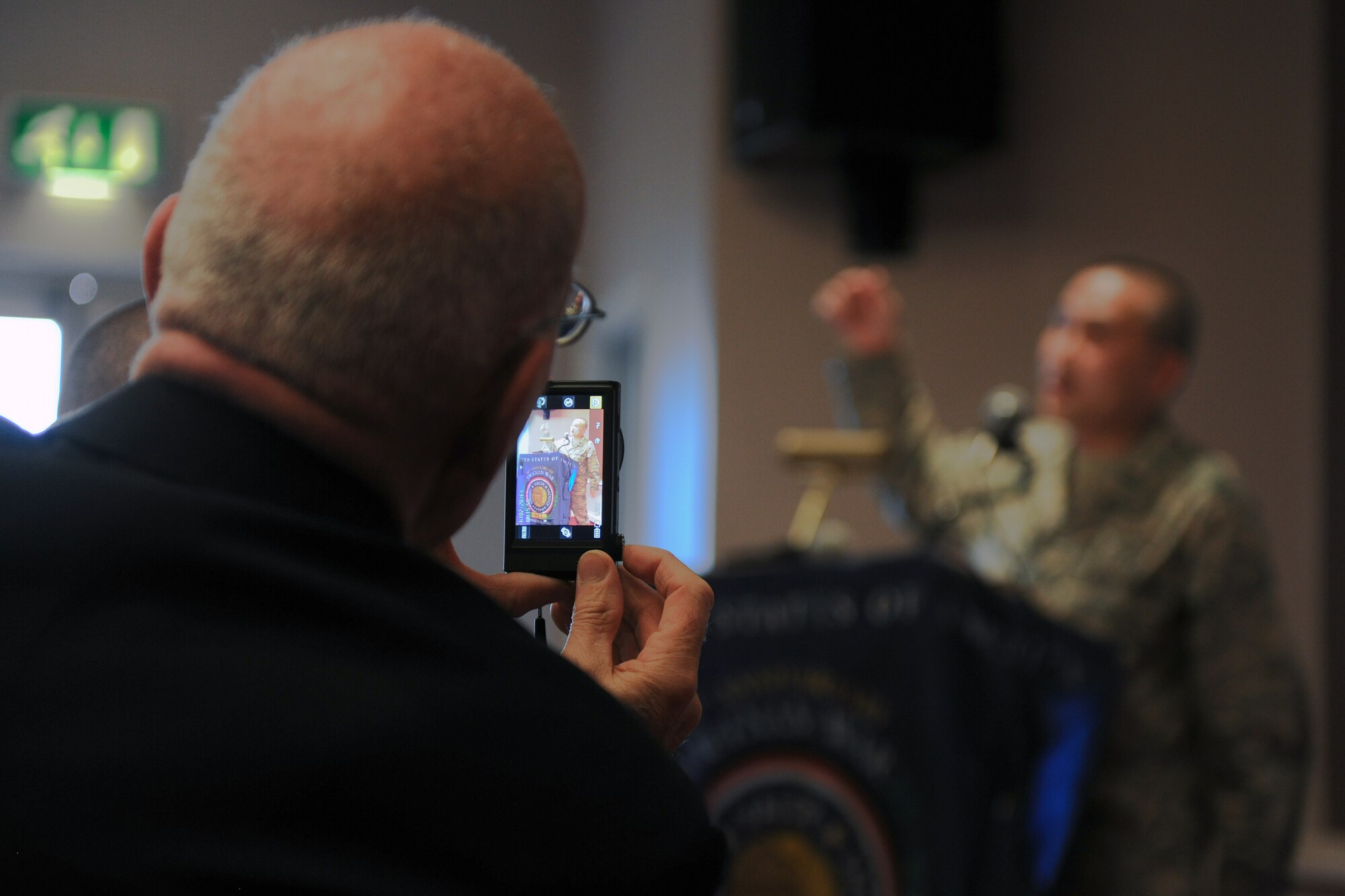 Retired U.S. Army Chaplain (Col.) William Carter takes a picture of his fellow guest speaker, U.S. Air Force Chaplain (Capt.) Joseph Tran, 422nd Air Base Group deputy chaplain, during the National Prayer Breakfast at RAF Croughton Feb. 13. Carter and Tran spoke shared their stories from the Vietnam War, offering insight into both the military and civilian aspects of the war. (U.S. Air Force photo by Staff Sgt. Brian Stives)