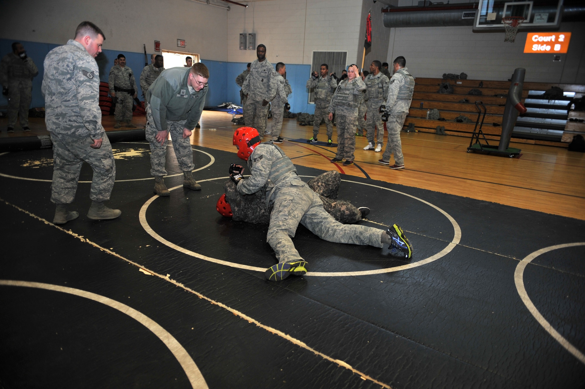Members of the 51st Security Forces Squadron call out instructions to their fellow defenders engaging in combatives training during a House of Pain exercise in the fitness center at Osan Air Base, Republic of Korea, Feb. 27, 2104. House of Pain mimics training used by the U.S. Marine Corps and completion is mandatory for all 51st SFS personnel. (U.S. Air Force photo/Airman 1st Class Ashley J. Thum)