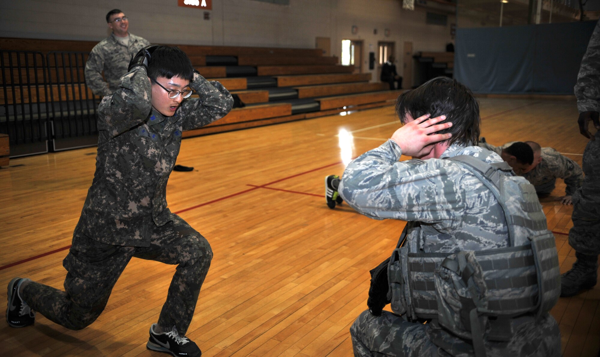 A member of the Republic of Korea air force air police completes jumping lunges with encouragement from a member of the 51st Security Forces Squadron during a House of Pain training event in the fitness center at Osan Air Base, ROK, Feb. 27, 2014. Defenders frequently train with their ROK counterparts to strengthen the relationship between the services. (U.S. Air Force photo/Airman 1st Class Ashley J. Thum)