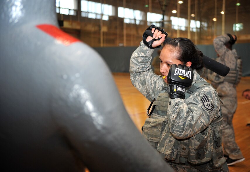 A defender from the 51st Security Forces Squadron wields a night stick prior to striking a rubber mannequin during a House of Pain training event in the fitness center at Osan Air Base, Republic of Korea, Feb. 27, 2014. Airmen were required to repeatedly strike the figure while shouting “get back,” to practice techniques they would use if they were attacked on duty. (U.S. Air Force photo/Airman 1st Class Ashley J. Thum)