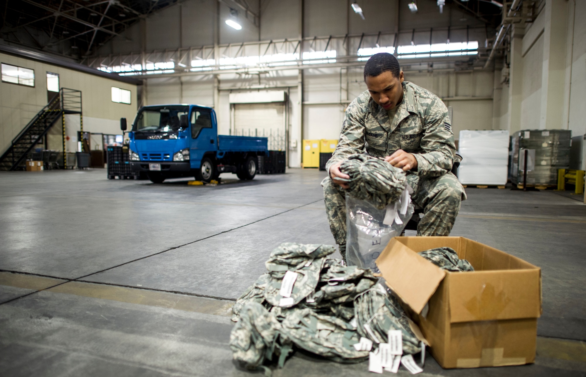 Senior Airman Ronald Sloane, 374th Logistics Readiness Squadron individual protective equipment technician, inspects helmet covers in preperation for Yokota’s upcoming Samurai Readiness Inspection at Yokota Air Base, Japan, Feb. 28, 2014. 374 LRS Airmen are responsible for all IPE used by Yokota Airmen during exercises and real-world contingencies. (U.S. Air Force photo by Staff Sgt. Stacy Moless)