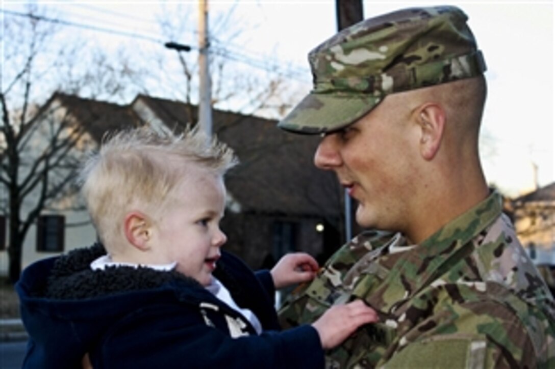 U.S. Army Sgt. Harry May holds his son, Tucker, for the first time in Wilmington, Del., Feb. 26, 2014, since he deployed with the 198th Expeditionary Signal Battalion last year.