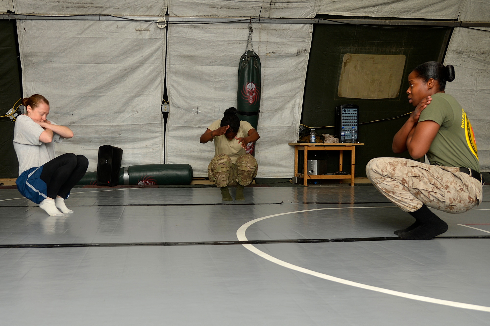 Instructor, U.S. Marine Cpl. Showni Anderson, Marine Corps Forces Central Command Coalition Engineer- Afghanistan supply chief, demonstrates a falling technique during the women’s self-defense class at Bagram Airfield, Afghanistan, Dec. 29, 2013. The class is held every Sunday from 3-5 p.m., and features techniques used in Marine Corps mixed martial arts. (U.S. Air Force photo by Senior Airman Kayla Newman/Released)