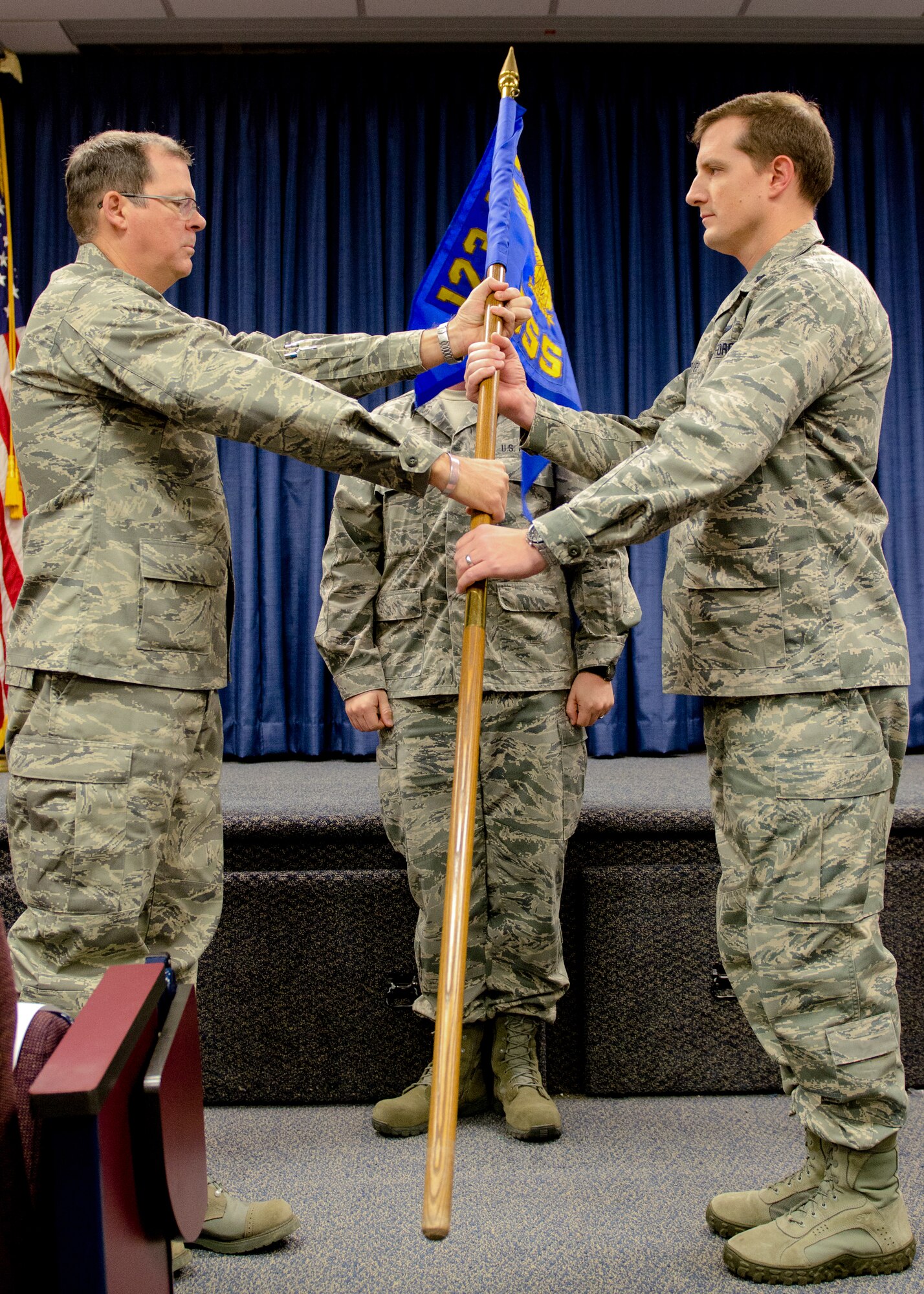 Col. Robert Hamm (left), commander of the 123rd Operations group, hands the 123rd Operations Support Squadron's new guidon to Lt. Col. Matthew Groves, squadron commander, during a redesignation ceremony at the Kentucky Air National Guard Base in Louisville, Ky., Nov. 24, 2013. Prior to the ceremony, the 123rd Operations Support Squadron was classified as a flight. (U.S. Air National Guard photo by Airman 1st Class Joshua Horton)