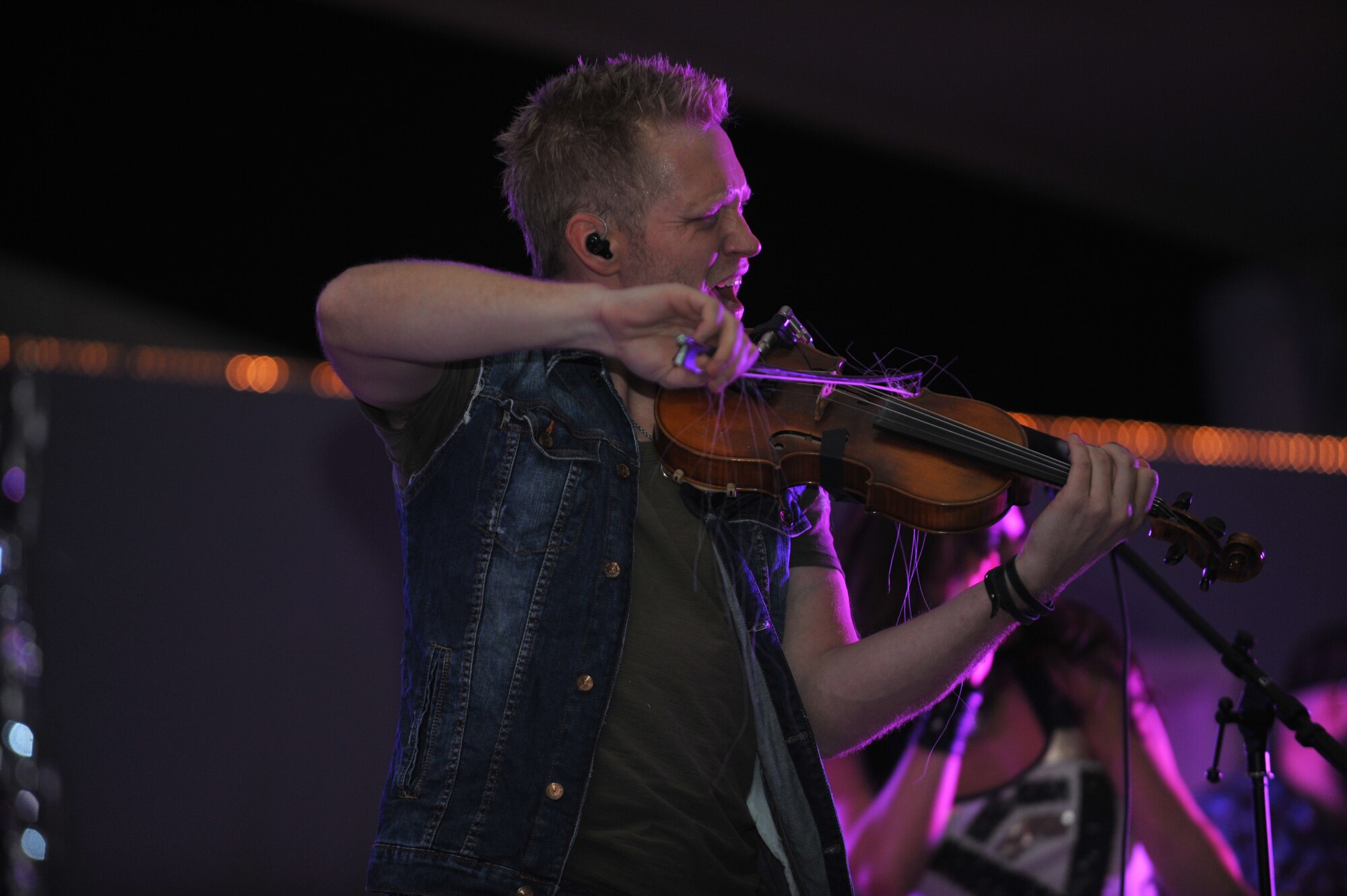 Nick Hoffman plays the fiddle during The Farm’s New Year’s Eve performance at the 379th Air Expeditionary Wing, Southwest Asia, Dec. 31, 2013. The Farm, a country music band that merges different genres into a unique sound, performed for deployed service members and helped ring in 2014 along with DJ Babey Drew and comedienne Iliza Shlesinger who is a former winner of NBC's Last Comic Standing. (U.S. Air Force photo by Master Sgt. David Miller)