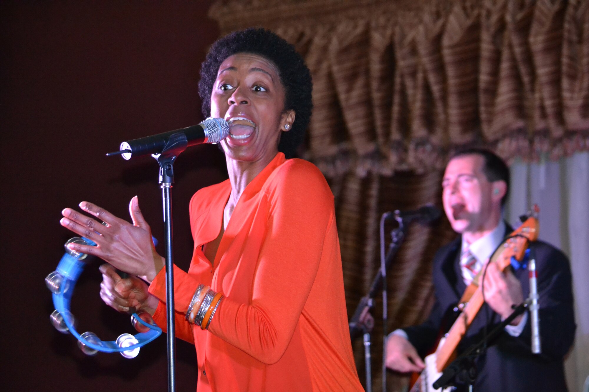 Technical Sgt. Felita LaRock, a vocalist for the U.S. Air Forces Central Command band, “Systems Go,” sings, while Technical Sgt. James Smith on bass guitar plays for service members New Year’s Eve, Dec. 31, 2013 in Southwest Asia.  LaRock, a native of Newark, OH, and Smith, a York, Pa. native, are deployed here from Wright-Patterson Air Force Base, home of the “Systems Go” band.  This AFCENT band performs a wide variety of hit songs from genres such as jazz, pop, rock and country, providing a high energy atmosphere raising joint and coalition morale.  During the holidays, the AFCENT band performed 40 shows in 30 days reaching an audience of 5,700 service members throughout the Central Command area of responsibility.   (U.S. Air Force Photo by Maj. Nicole David)