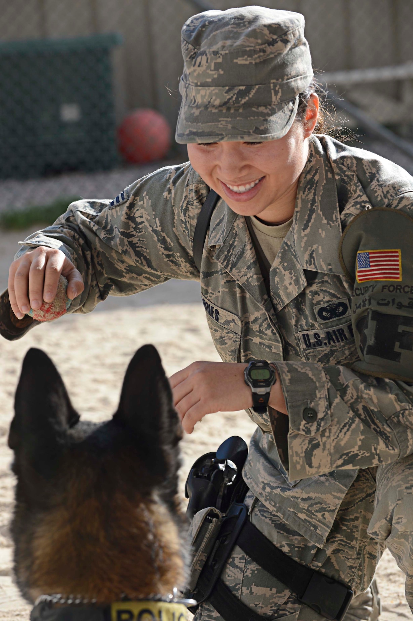 Senior Airman Angela Jones, 386th Expeditionary Security Forces Squadron, plays with her seven year old Belgian Malinois, Chester after his training at an undisclosed location in Southwest Asia. Jones is a military working dog handler, deployed from Nellis Air Force Base and a Lafayette, Louisiana native. (U.S. Air Force photo by Senior Airman Desiree W. Moye)
