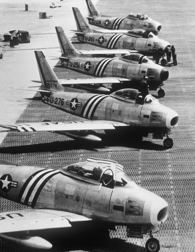 A quintet of F-86 Sabrejets of the 5th Air Force's veteran 4th Fighter Interceptor Wing sit on the tarmac after  a combat patrol over enemy territory in this undated photo as crew-chiefs and mechanics make the necessary inspection and repairs to ready the sturdy aircraft for another flight.