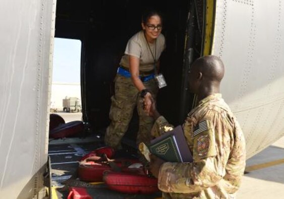 Staff Sgt. Deng Pour, non-commissioned officer in charge of religious affairs with the Combined Joint Task Force-Horn of Africa, greets Airman 1st Class Pamela Thompson, 81st Expeditionary Rescue Squadron communication and navigation specialist at Camp Lemonnier, Djibouti, Dec. 13, 2013. (U.S. Air Force photo by Staff Sgt. Antoinette Gibson)

